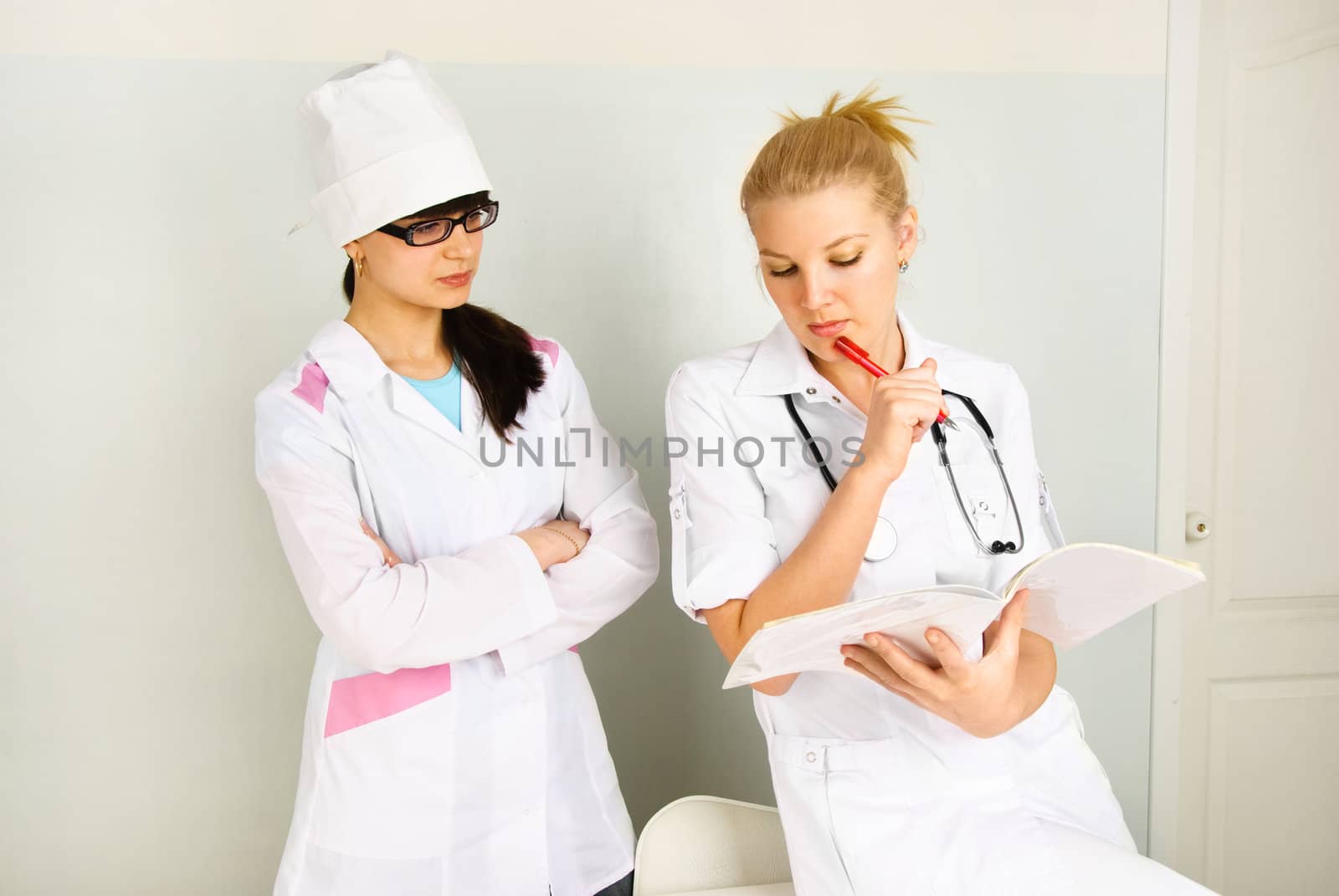 portrait of a young thoughtful doctor with her assistant in the office