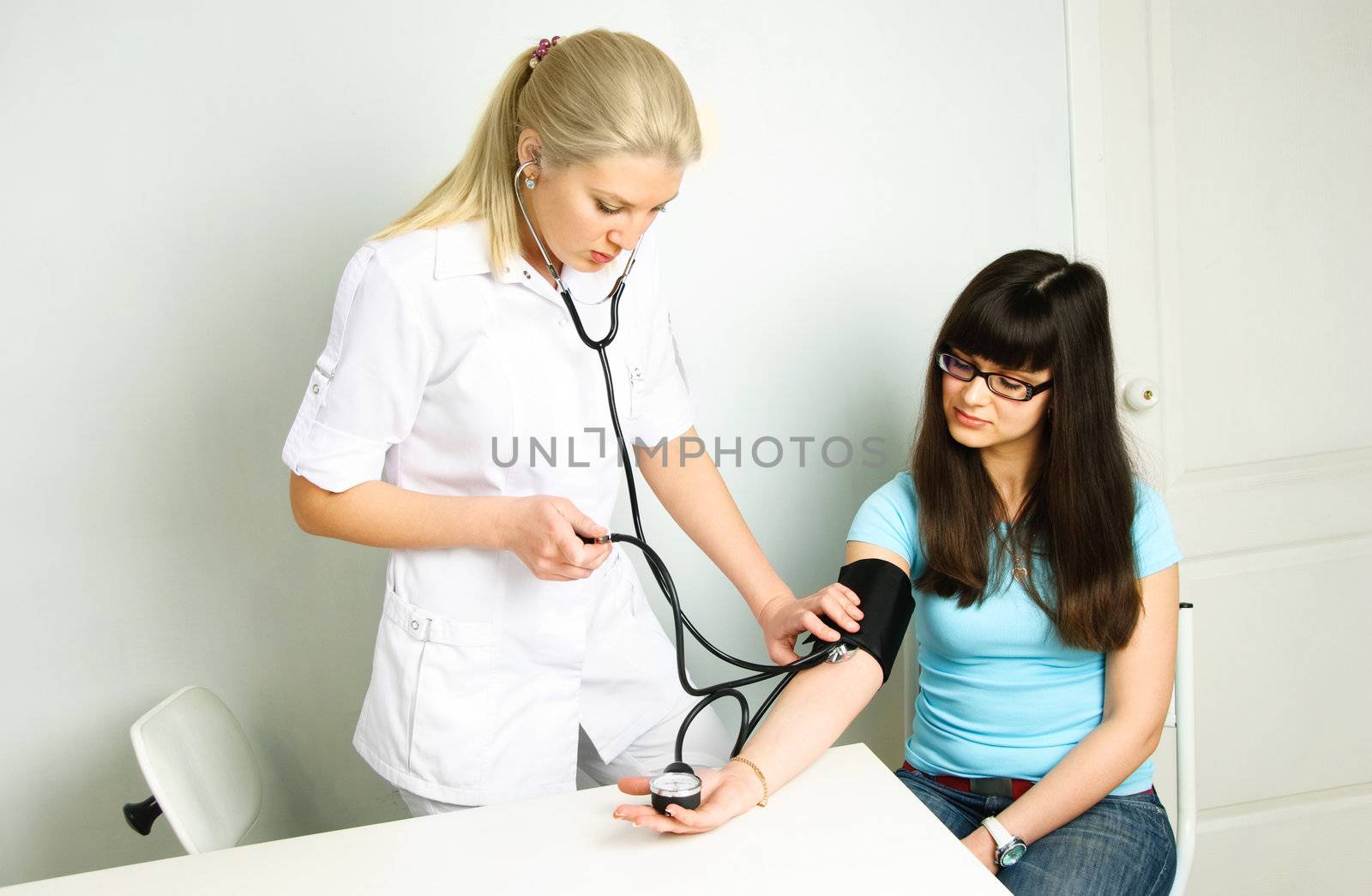 doctor measuring the blood pressure by lanak