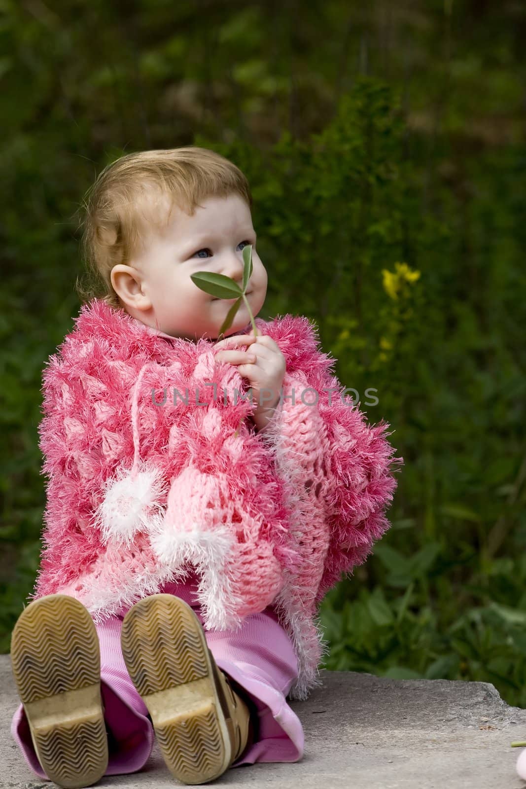 little baby holds a green leaf