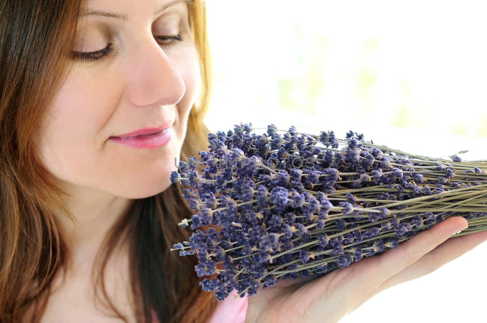 Mature woman smelling bunch of dried lavender