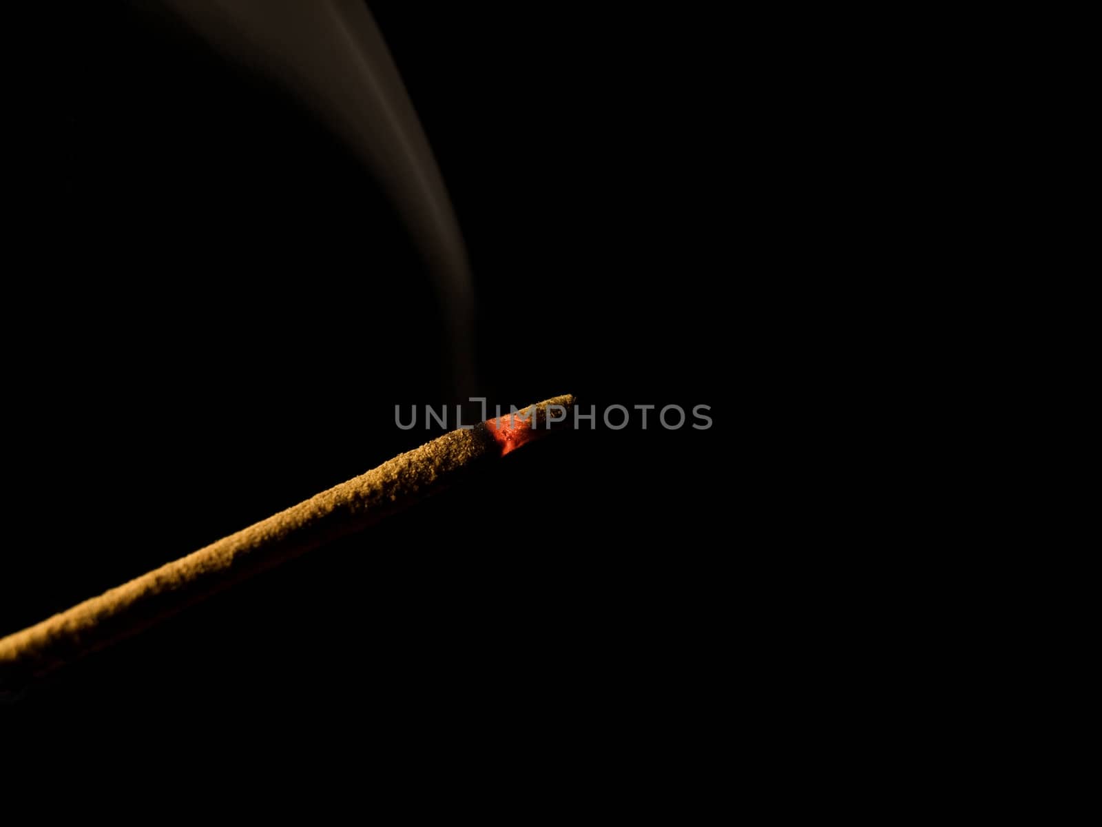 Closeup of an incense stick isolated on black