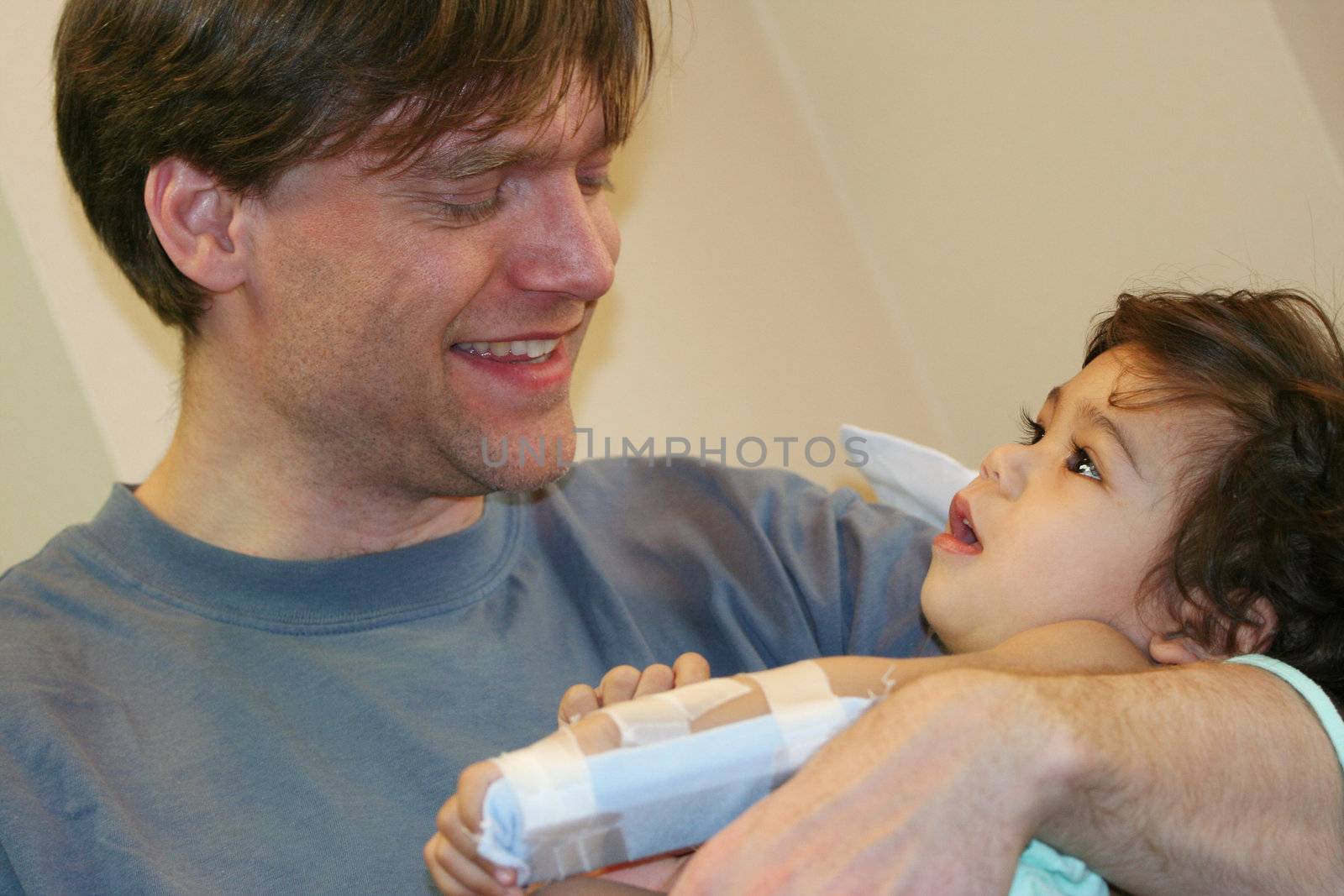 Father holding sick baby in hospital