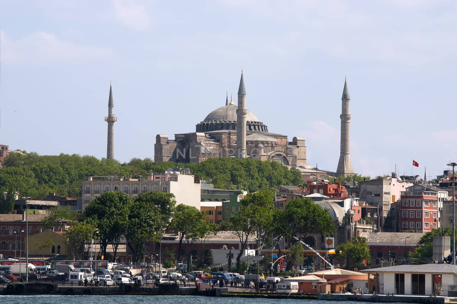 Antique mosque with four minarets over blue sky