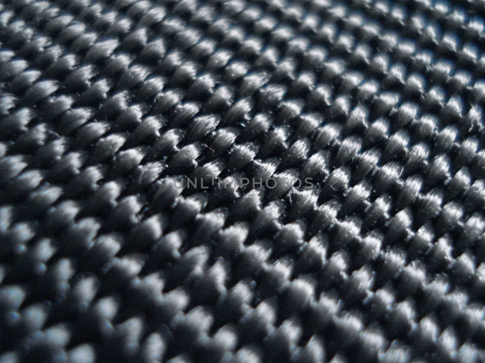 Black fabric reveals an intricate pattern of ridges up close.