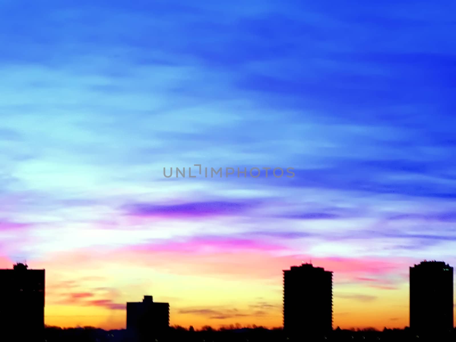 The silhouette of a city skyline on an array of sunset colors.