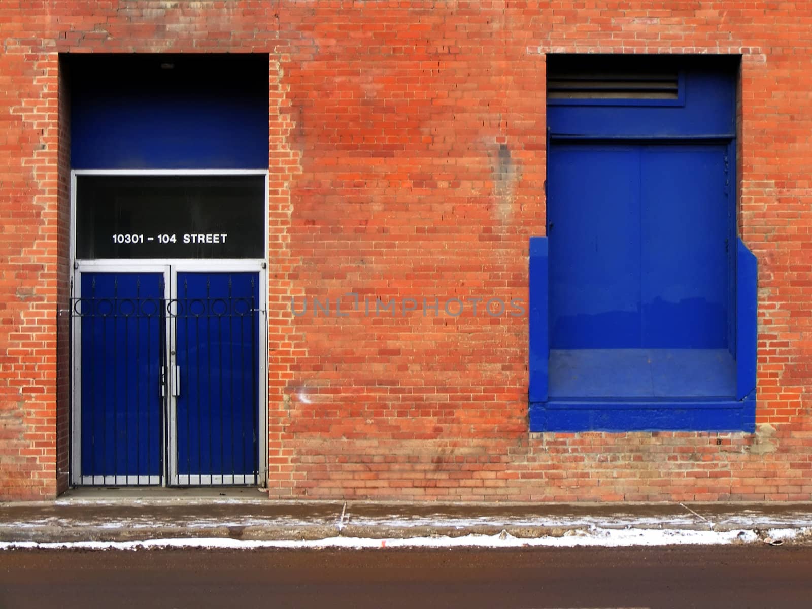 Blue windows and doors on a brick building.