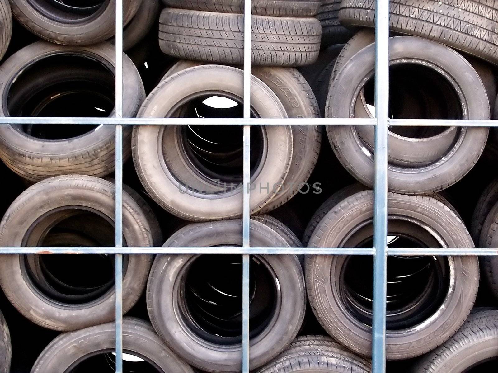 A pattern of old used tires behind a tire shop