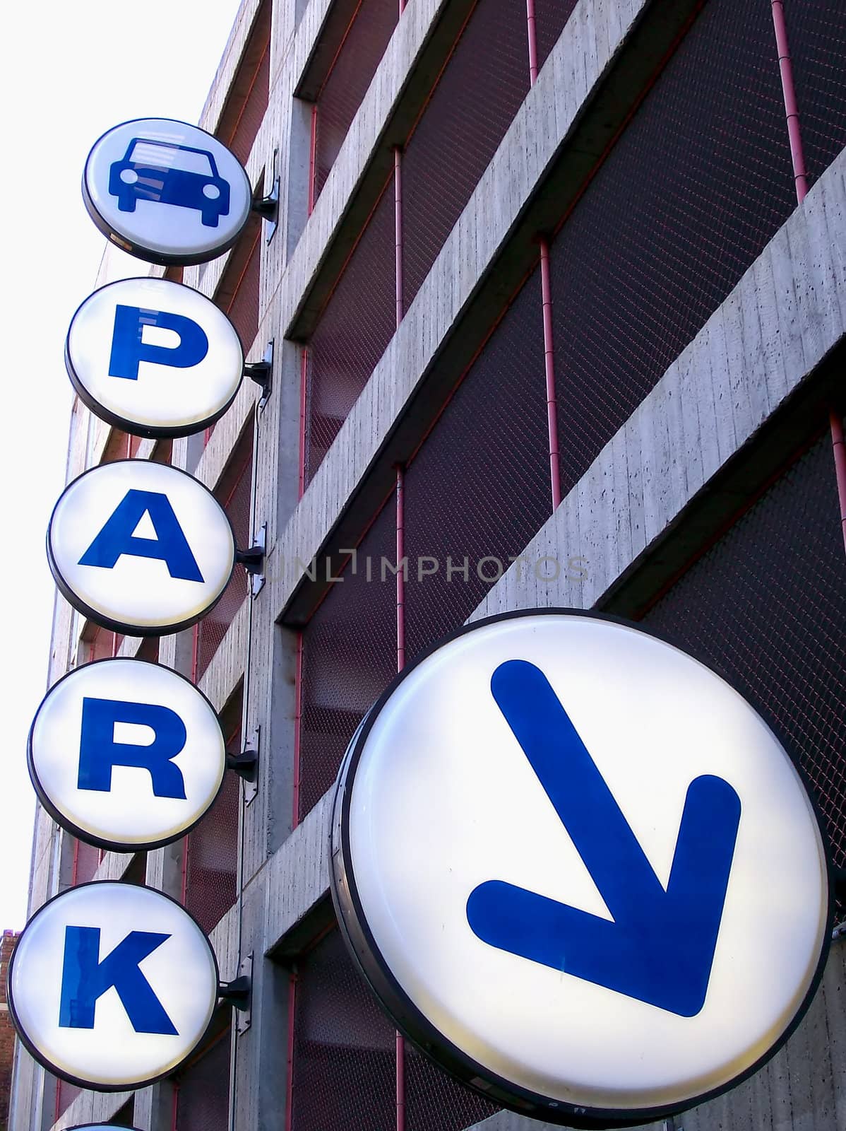 Lit parking structure sign directing you into the lot.