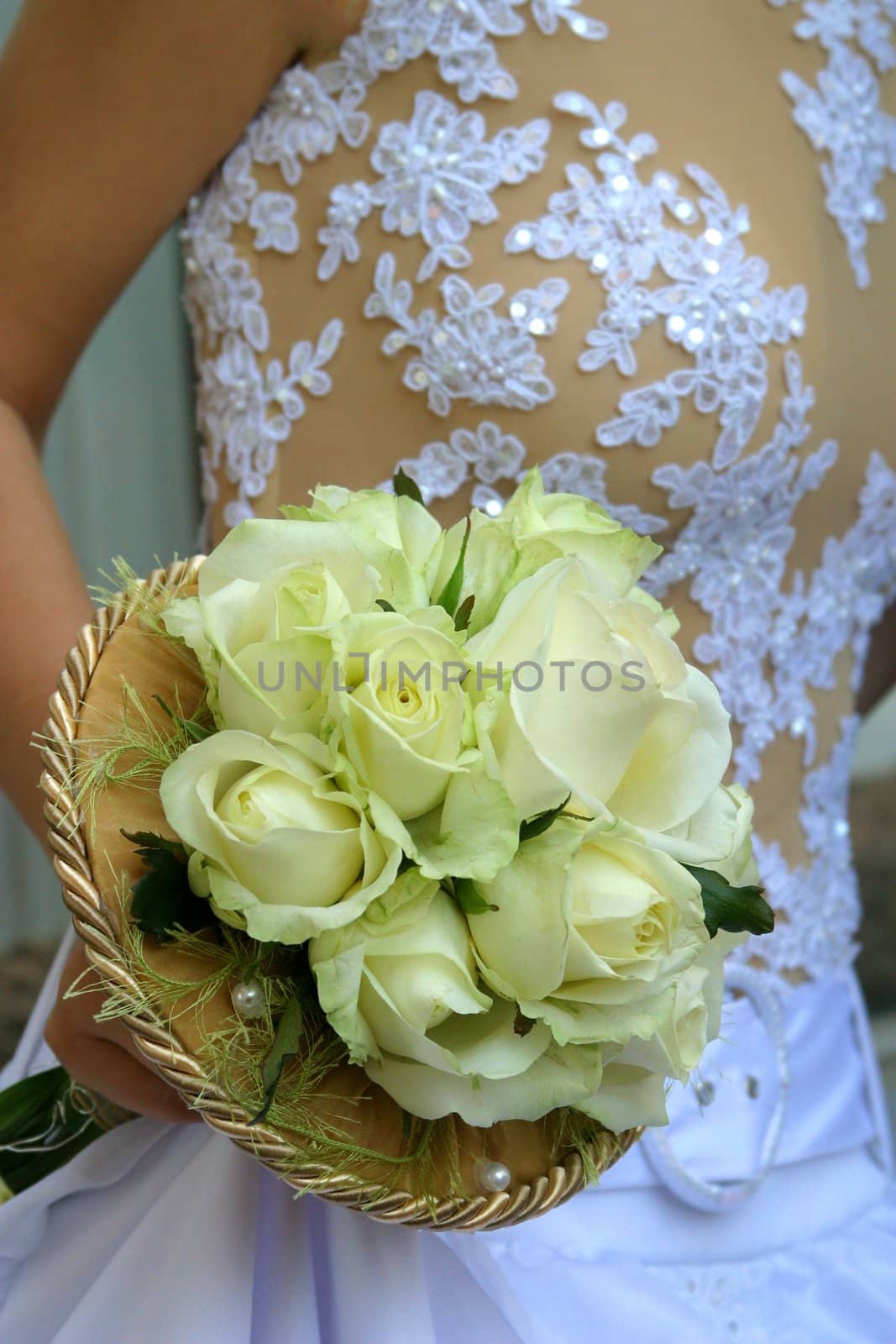 Wedding bouquet from white roses in a hand of the bride