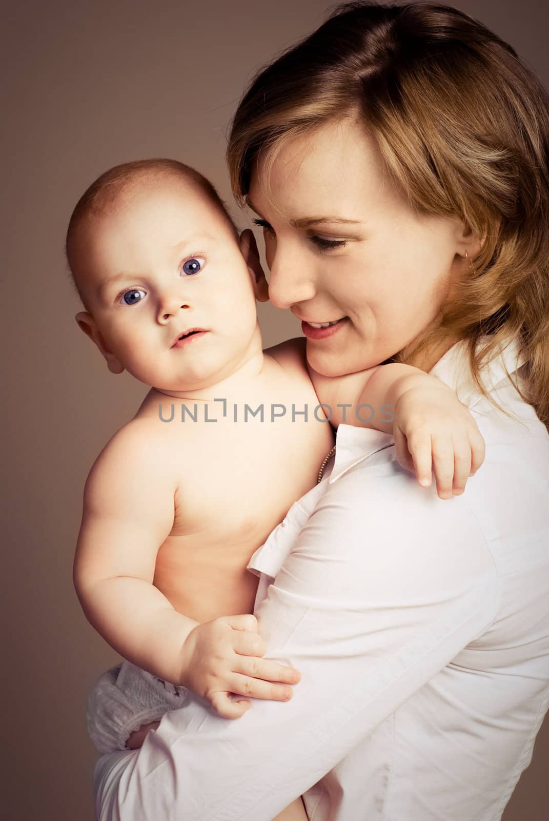 studio portrait of a young happy beautiful mother with her little baby 