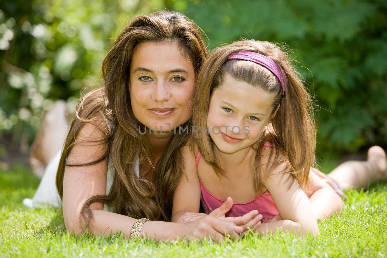 Beautiful pair of mother and daughter outside in the grass