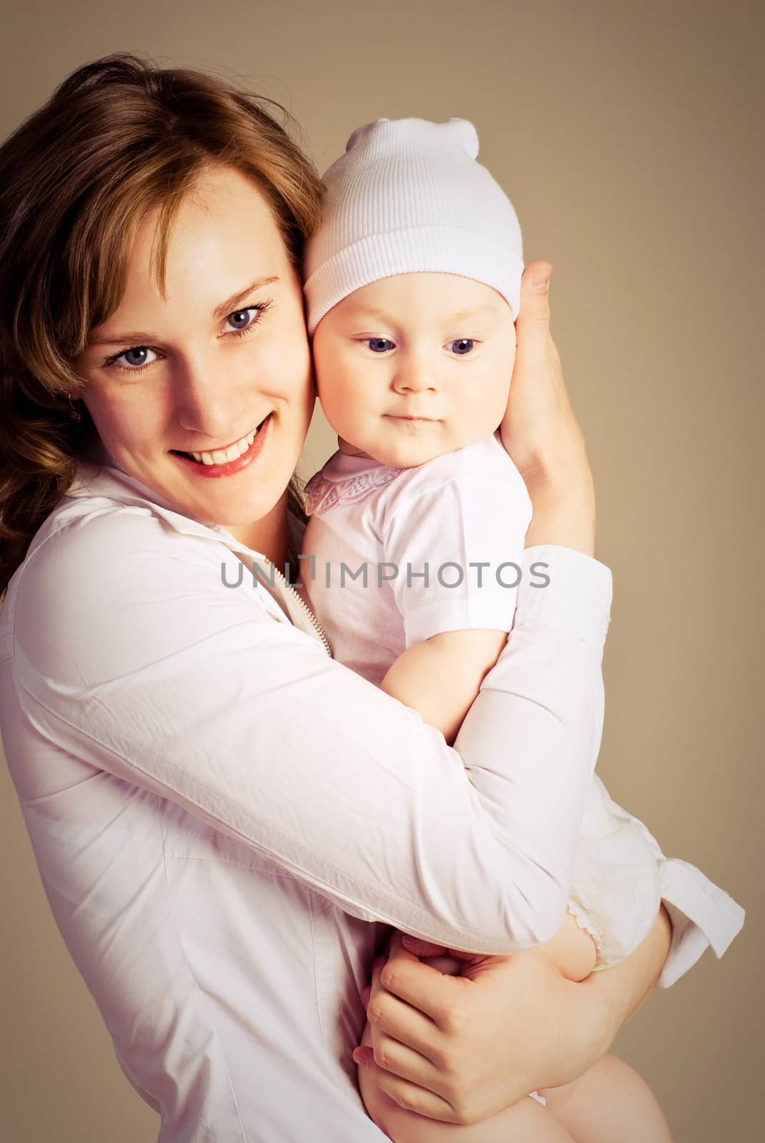 studio portrait of a young happy beautiful mother with her little baby 