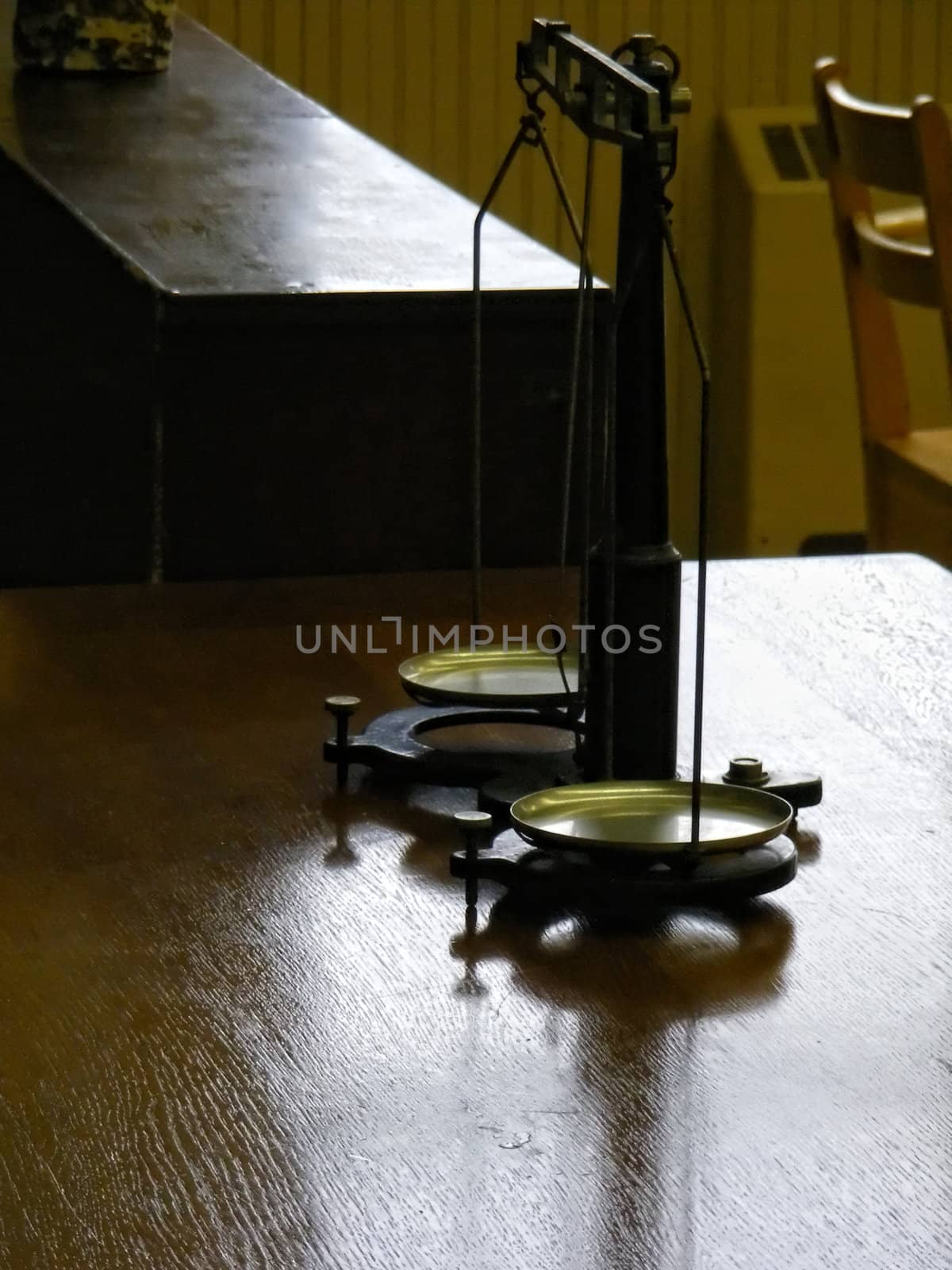 Antique scales on a desk in a historic classroom.