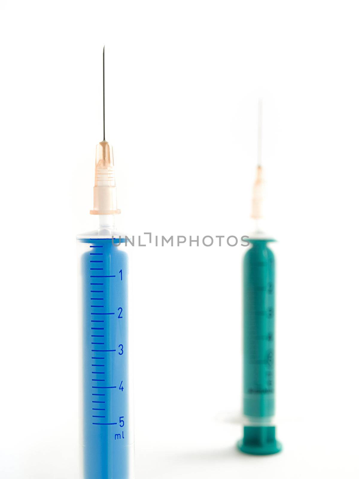 two syringes against clear white background taken from up close