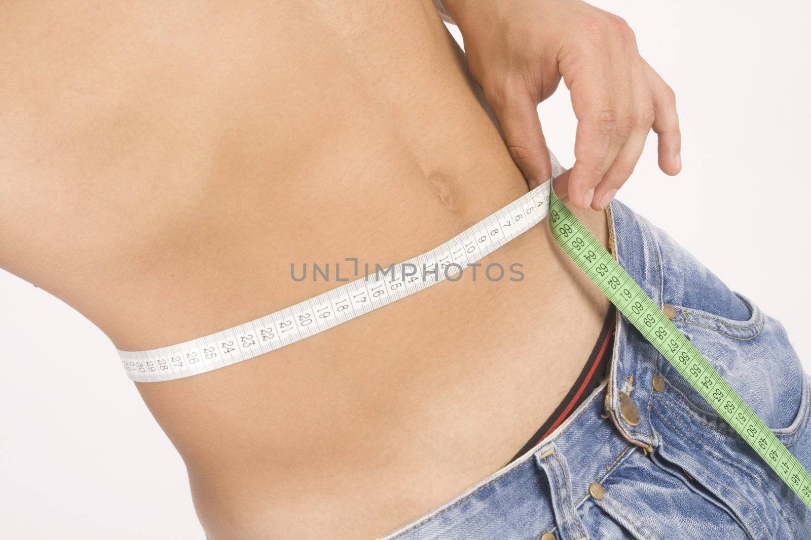Young pretty man measuring his perfect body isolated on white

