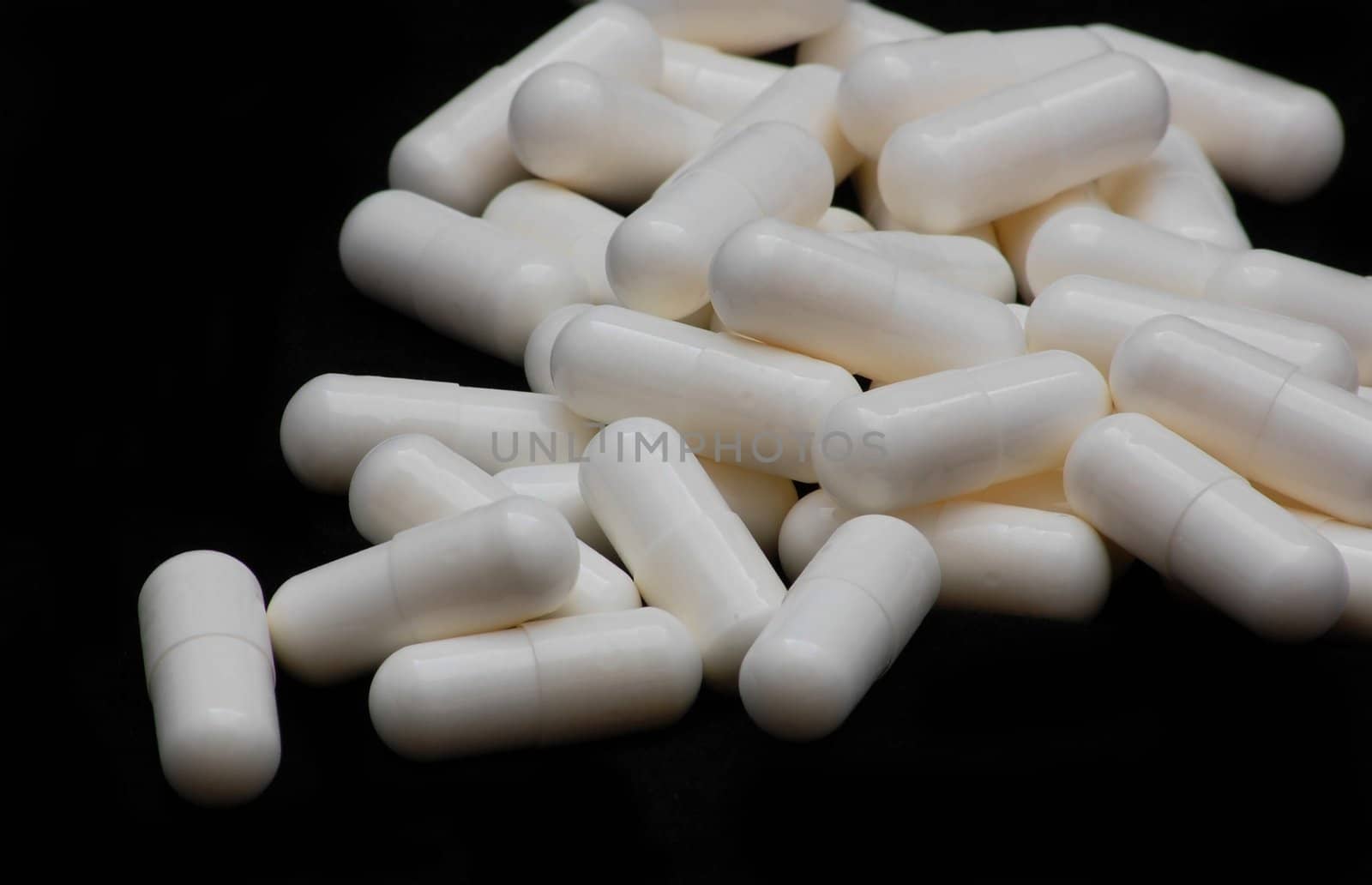 white capsules isolated on the black background