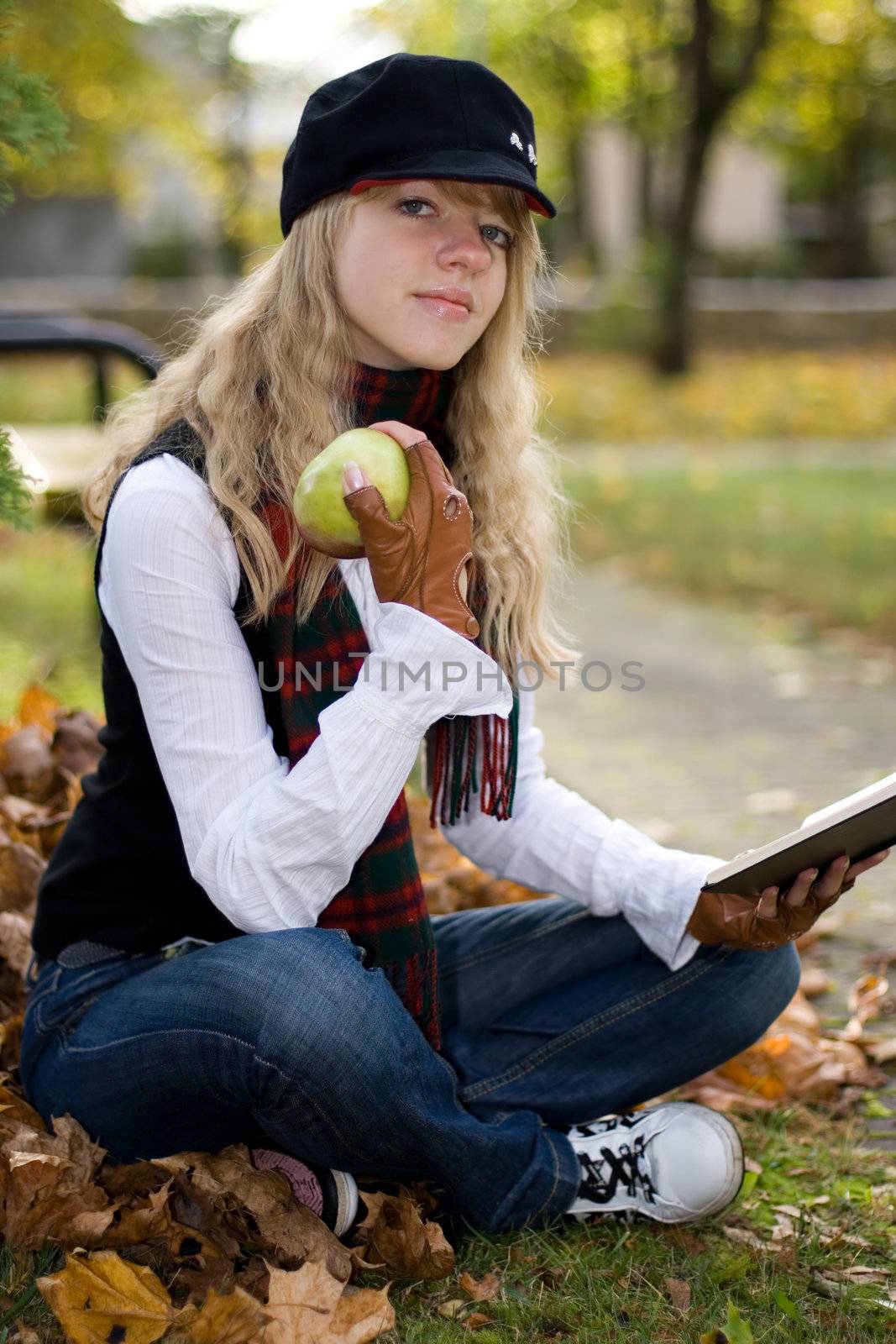 Student girl studying outside in the autumn