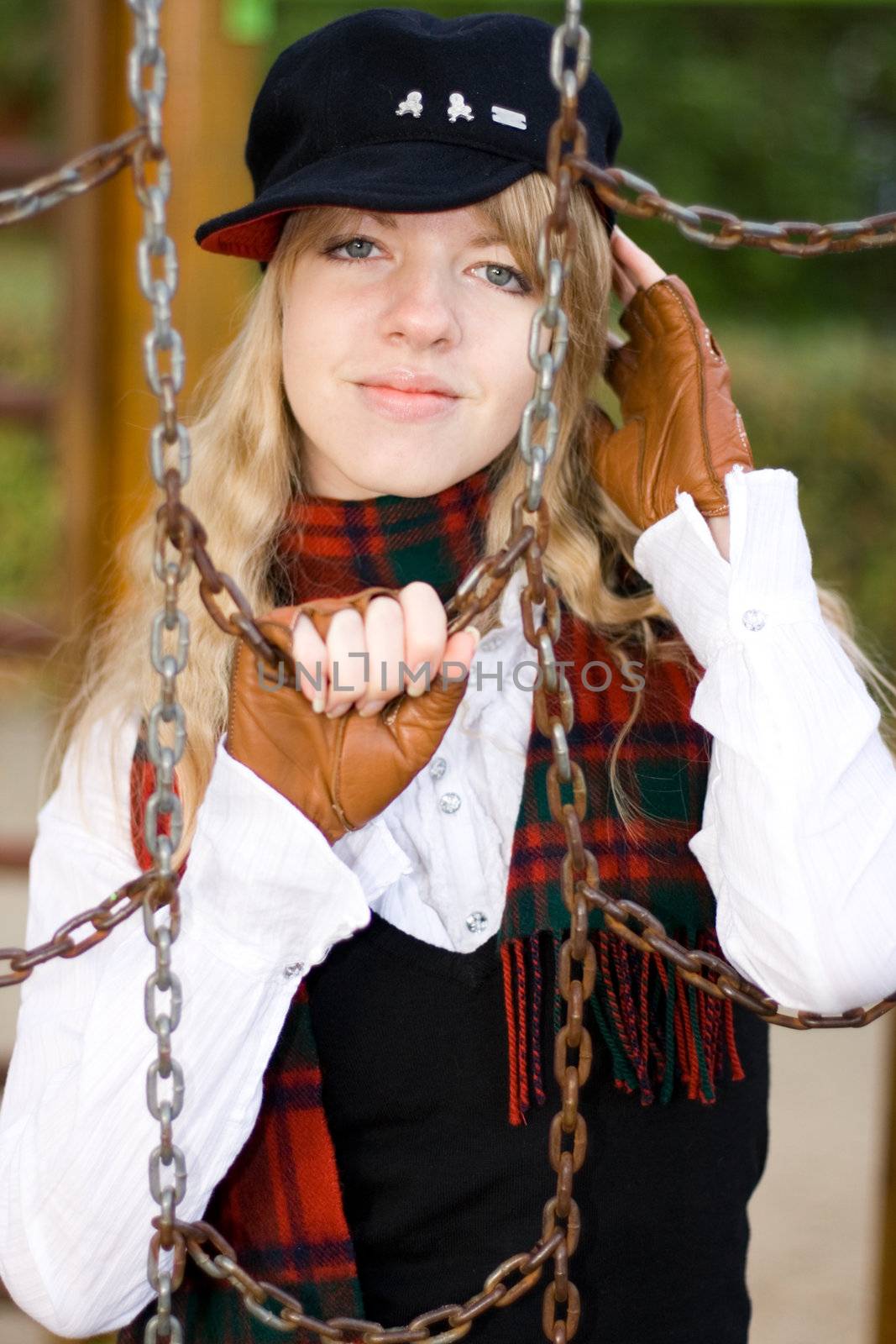 Young girl behind the chains on a playground