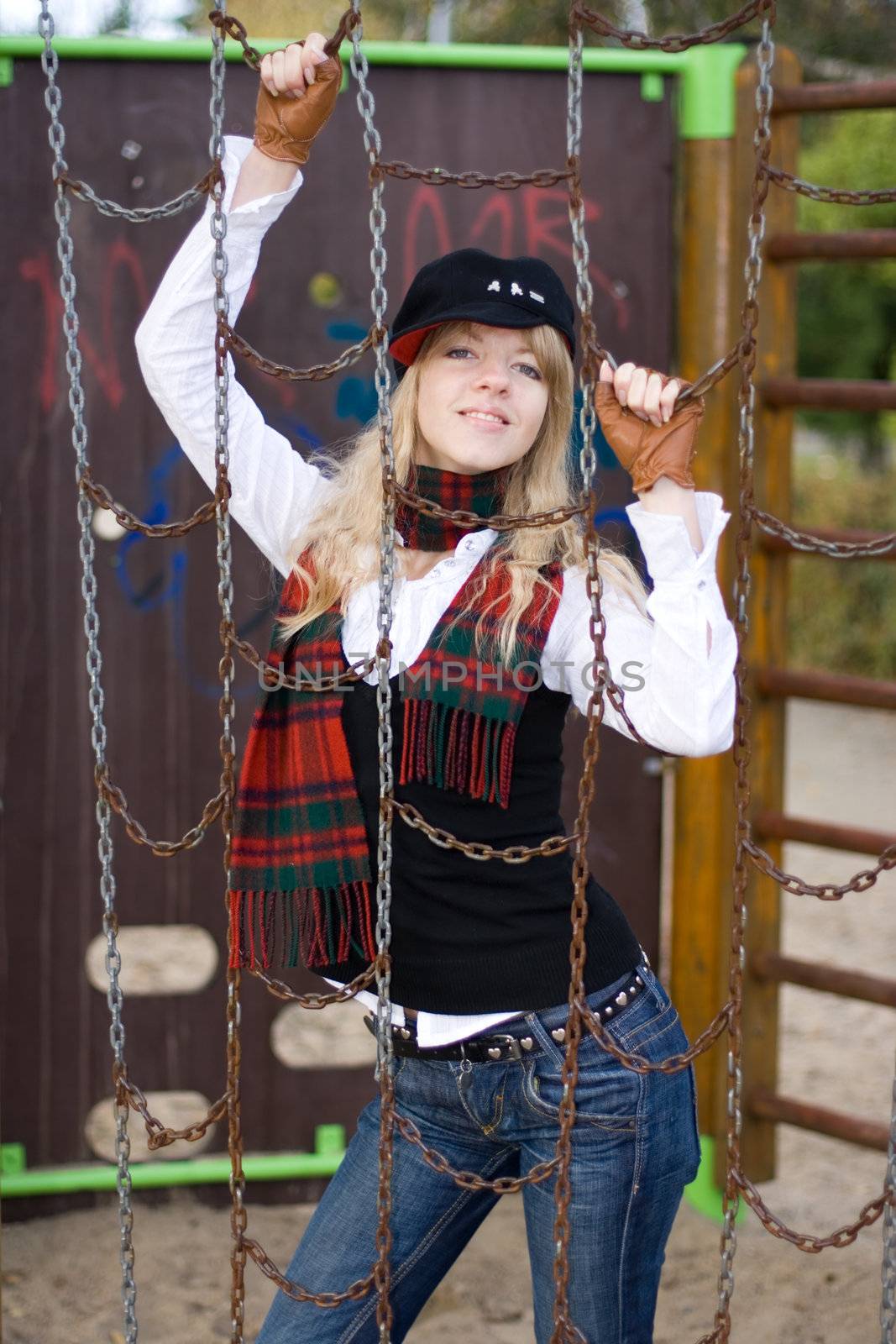 Young girl behind the chains on a playground