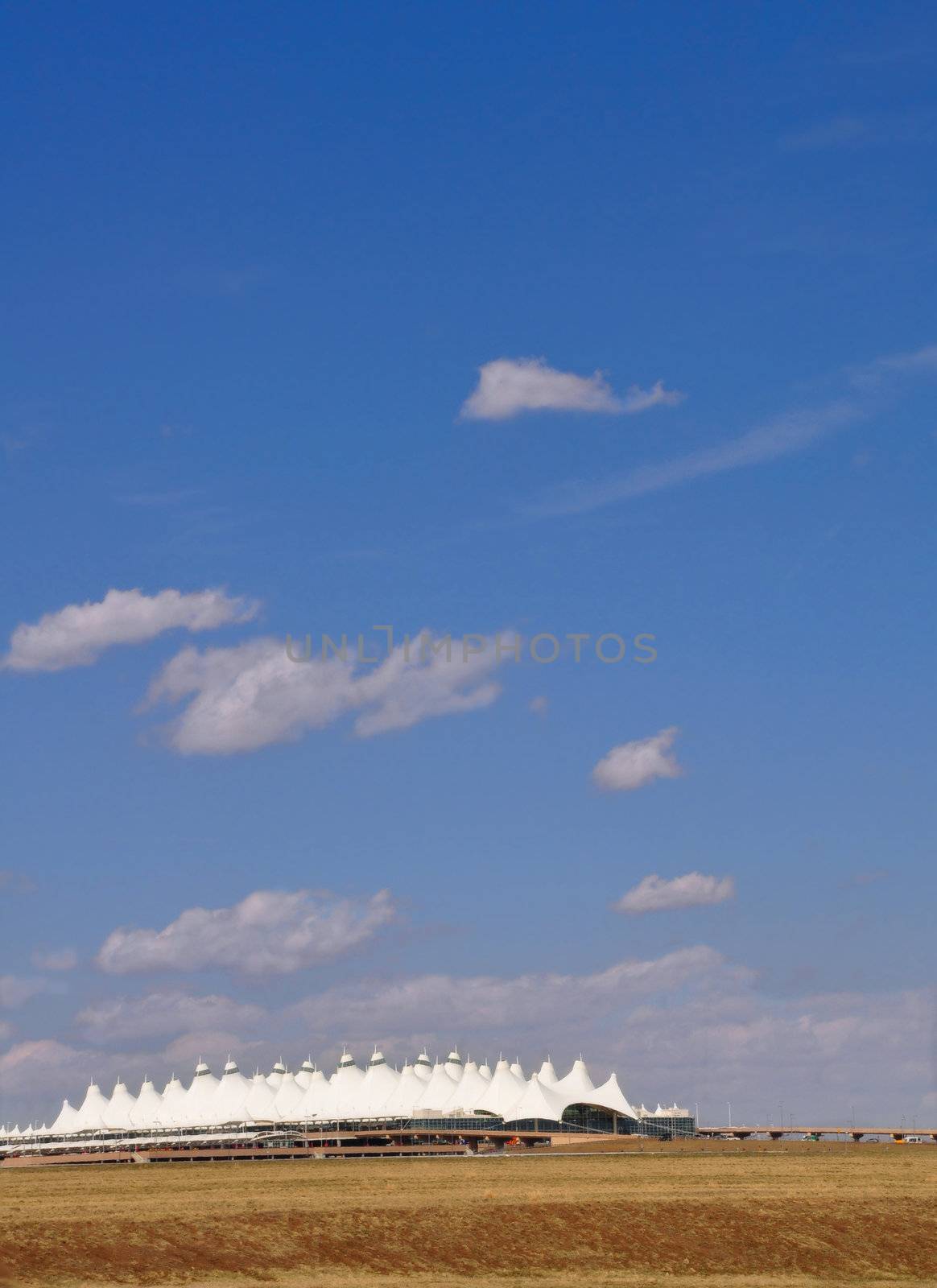 The points of the tent-like terminal of Denver International Airport stick out of the high plains under a blue Colorado sky.