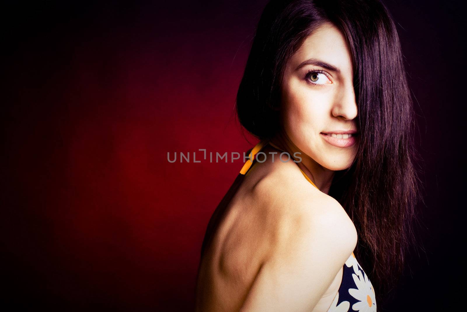studio portrait of a sexy young brunette woman against red background