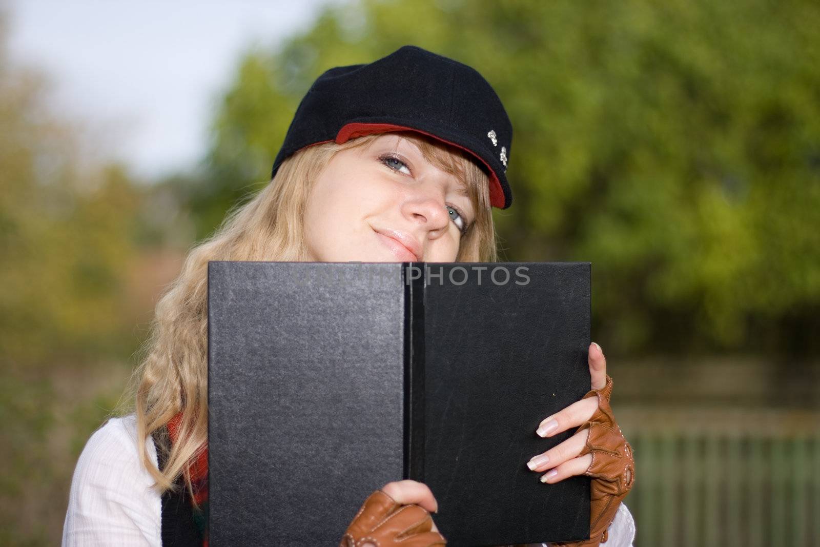 Student girl with a book in a hat by mihhailov