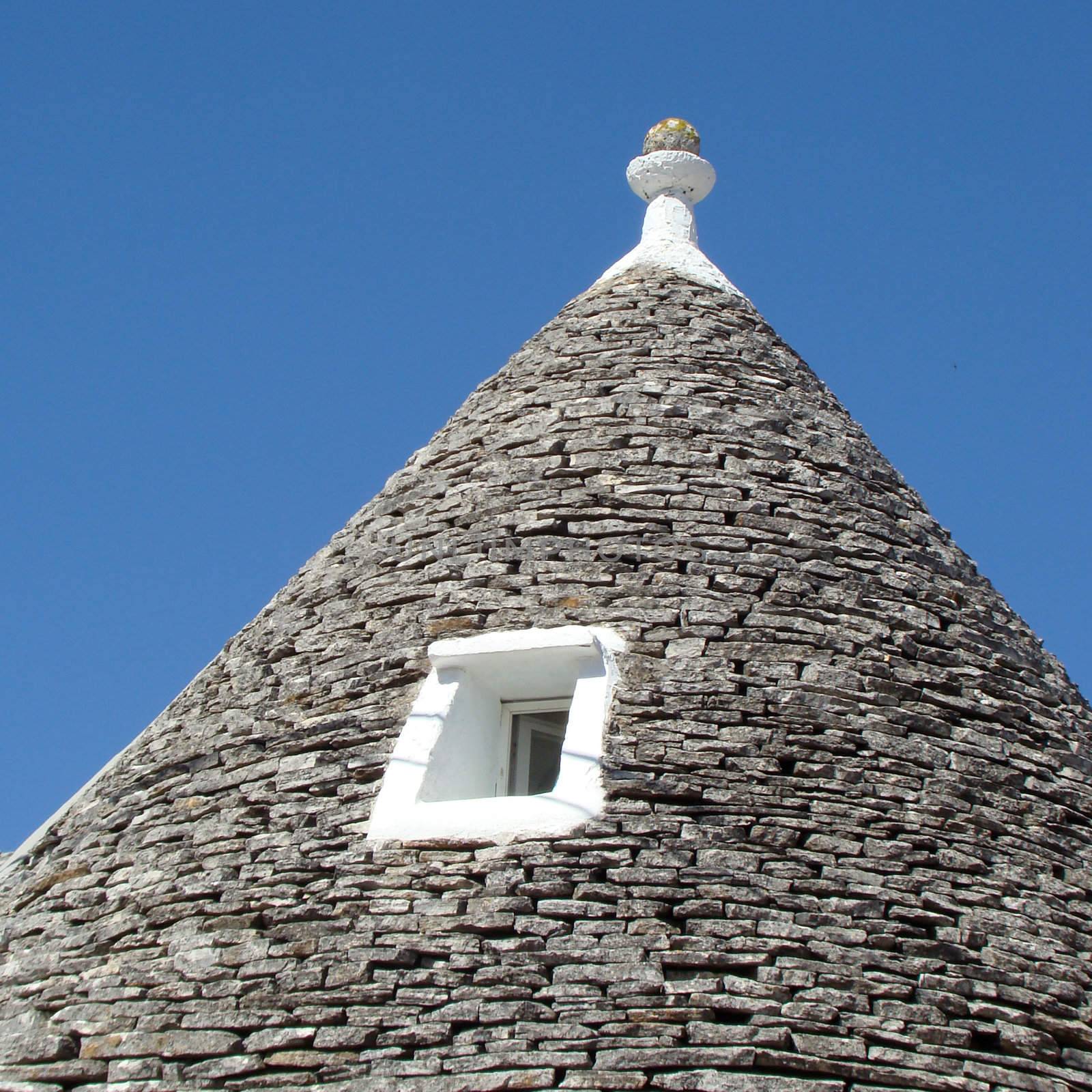 conical roof of trullo house in Apulia, region in Italy. Trulli are local,traditional Apulian stone dwelling with a conical roof. They may be found in the towns of Alberobello, Locorotondo, Fasano, Cisternino, Martina Franca and Ceglie Messapica.