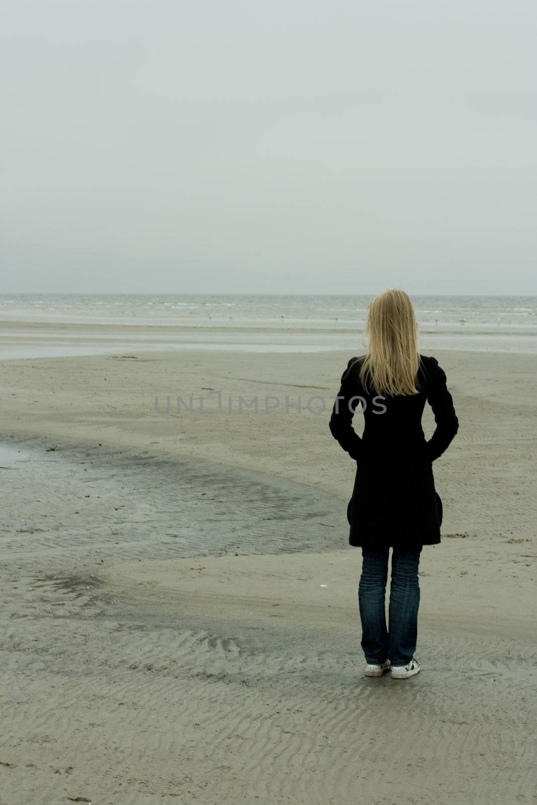 A lonely girl standing at the seashore