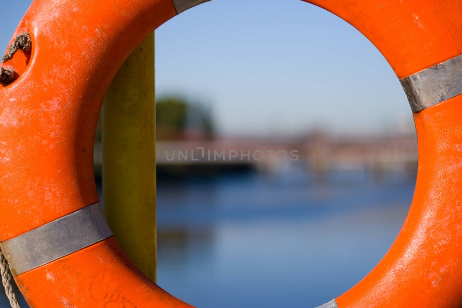 Orange life buoy hanging near the river