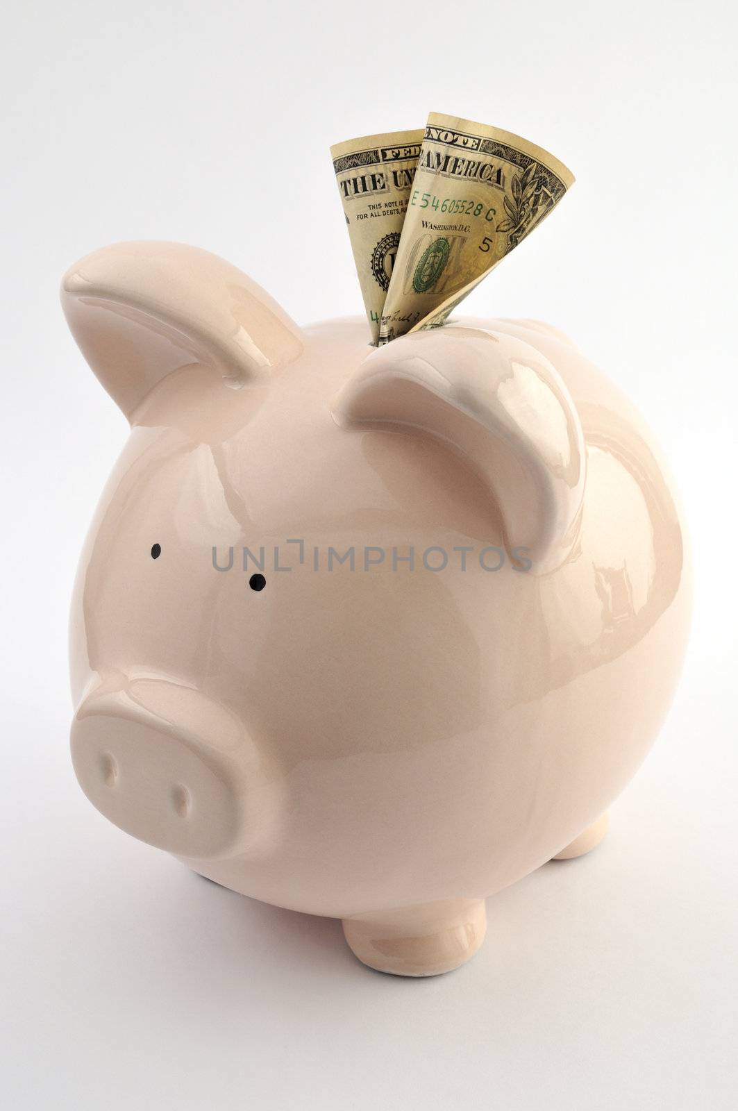 Ceramic piggy bank with one dollar note, isolated on white background
