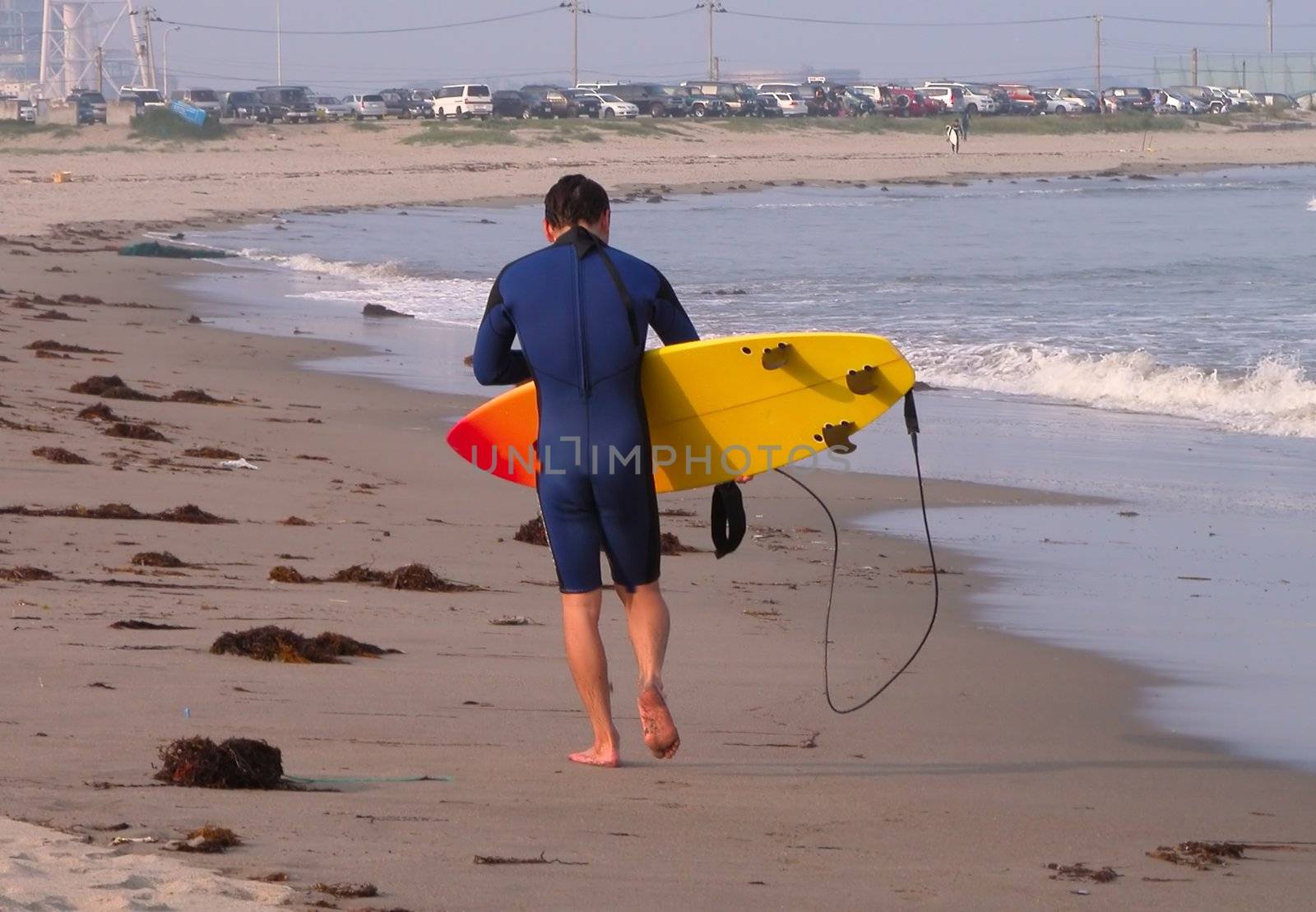 Surfer walking on the ocean beach          