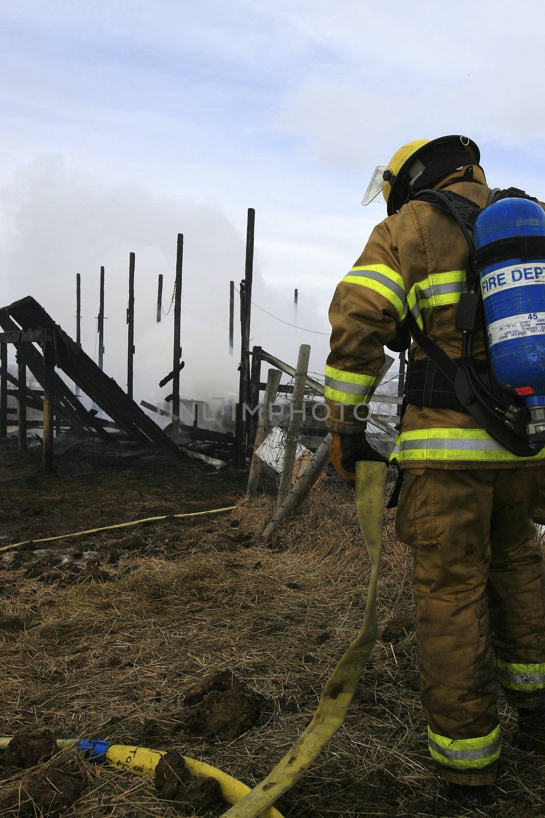 A firefighter cleana up after putting out a barn fire.