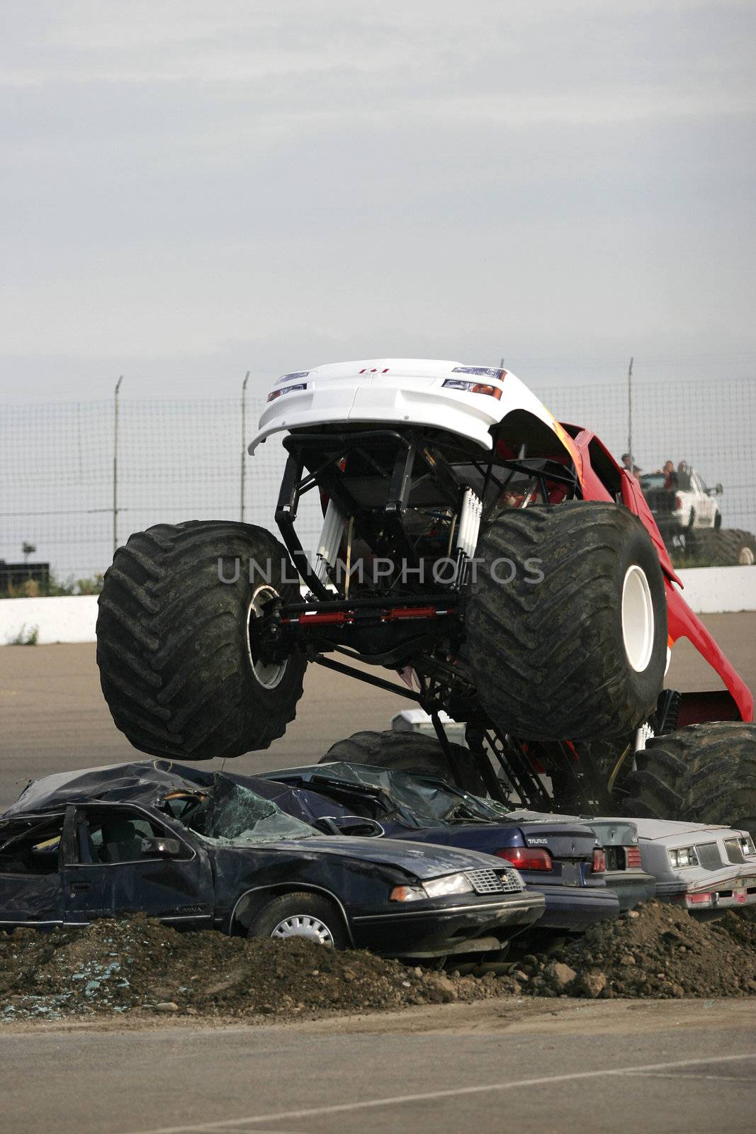 A monster truck jumps over cars