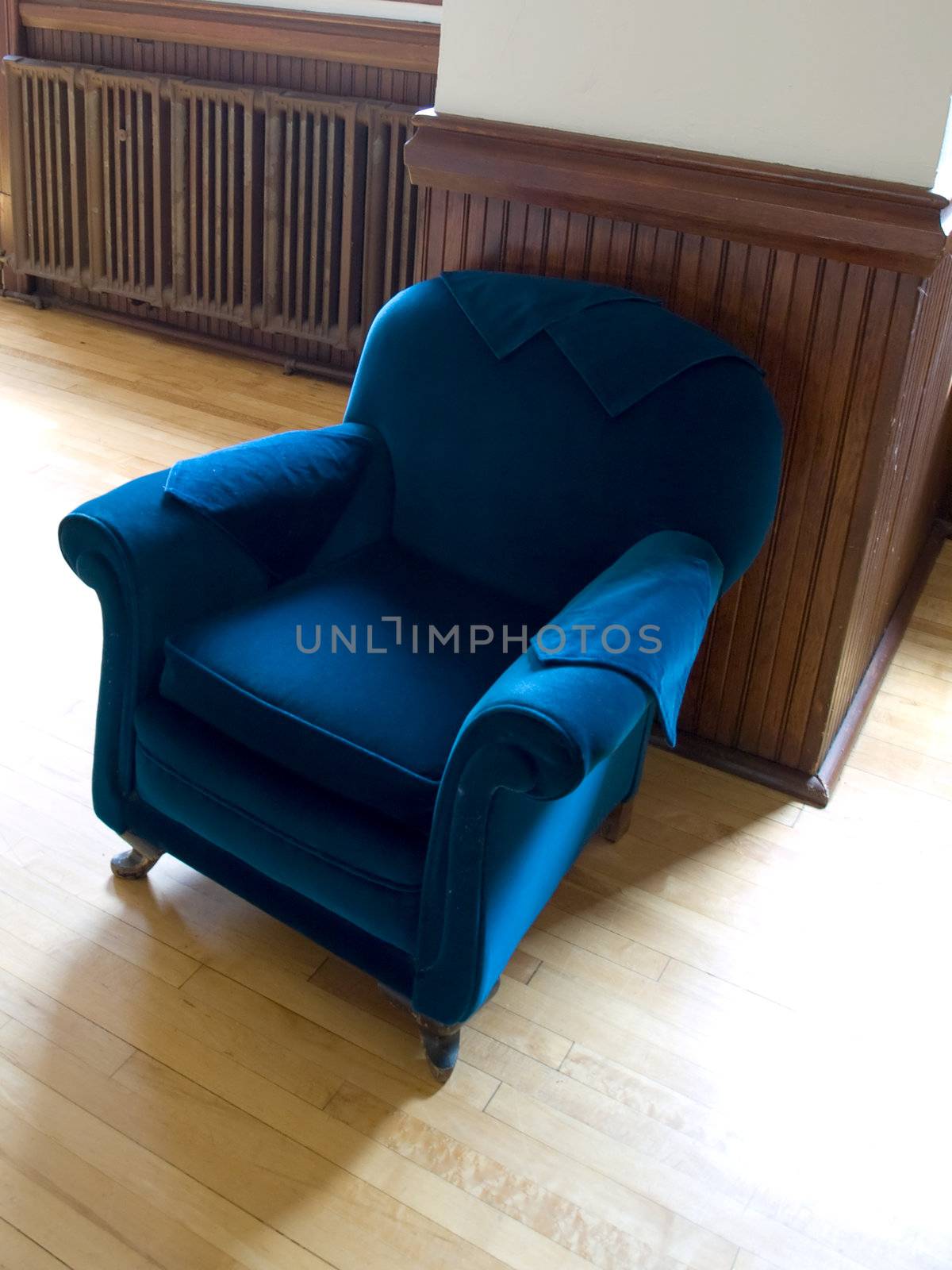 Velvet blue armchair inviting in a warm sunlit room.