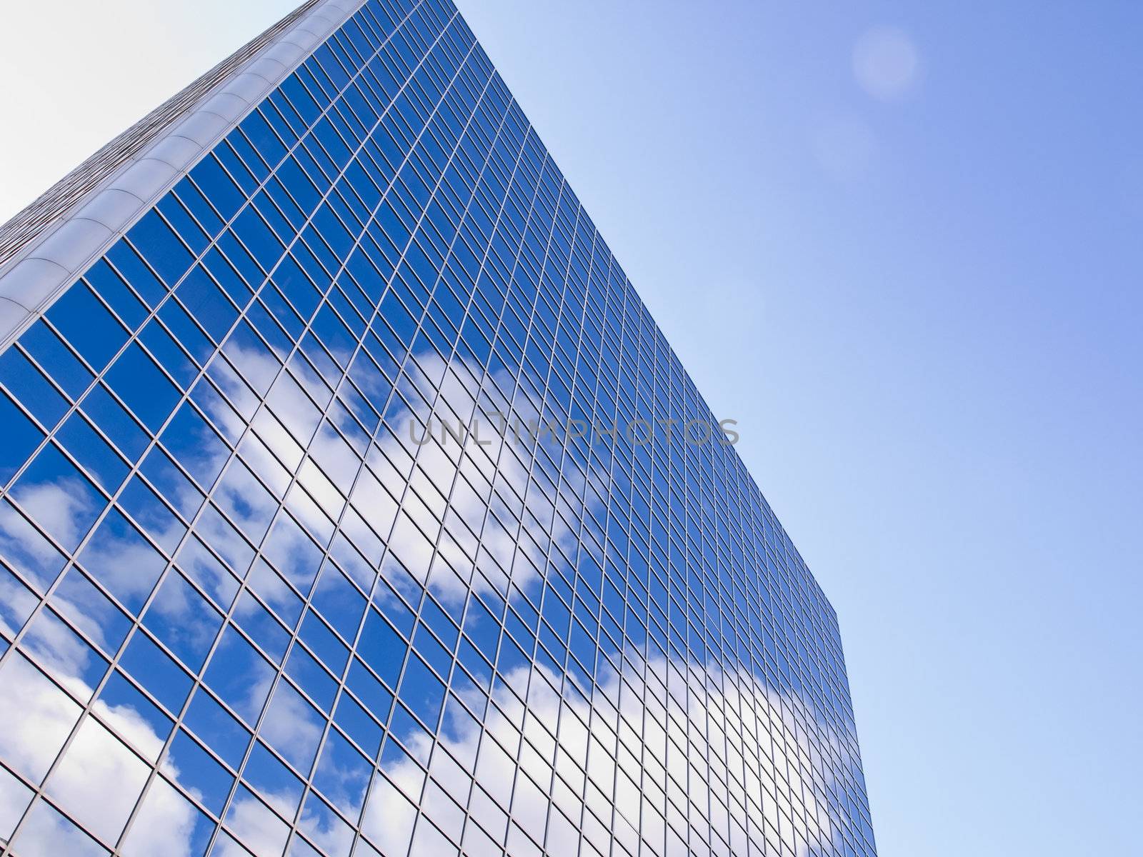 A reflection of clouds in a brilliant blue tower.