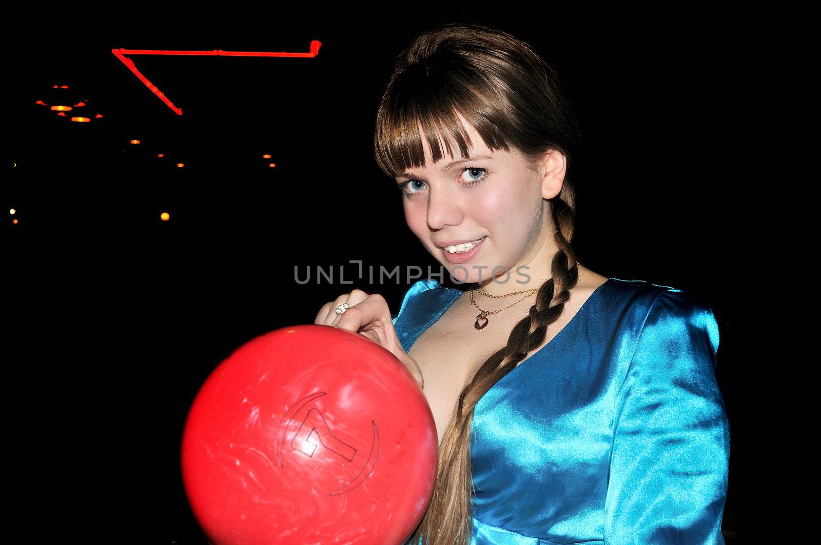  	young beautiful girl is holding red bowling ball