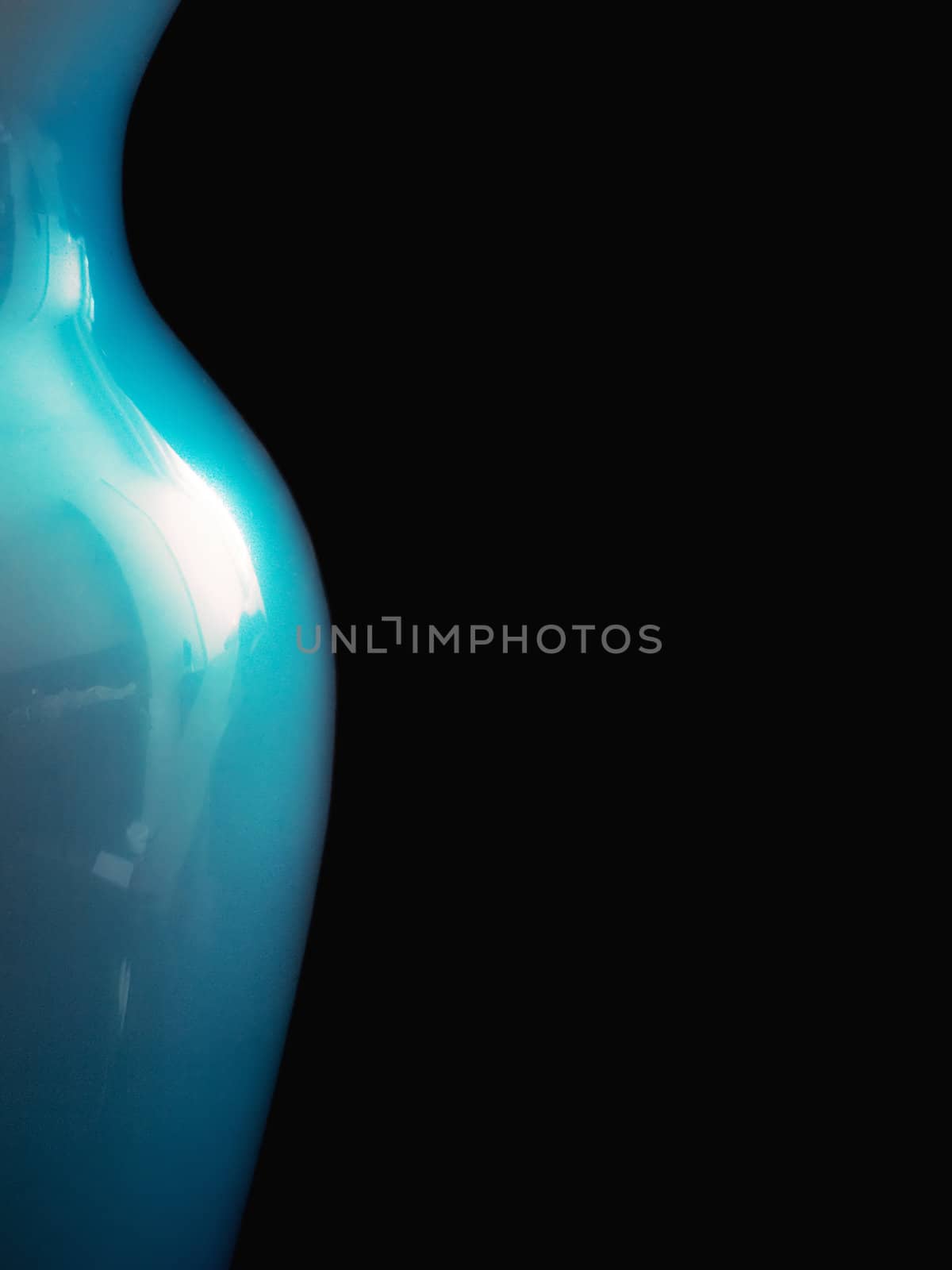 Blue vase detail and sensual curve shot on a black background.