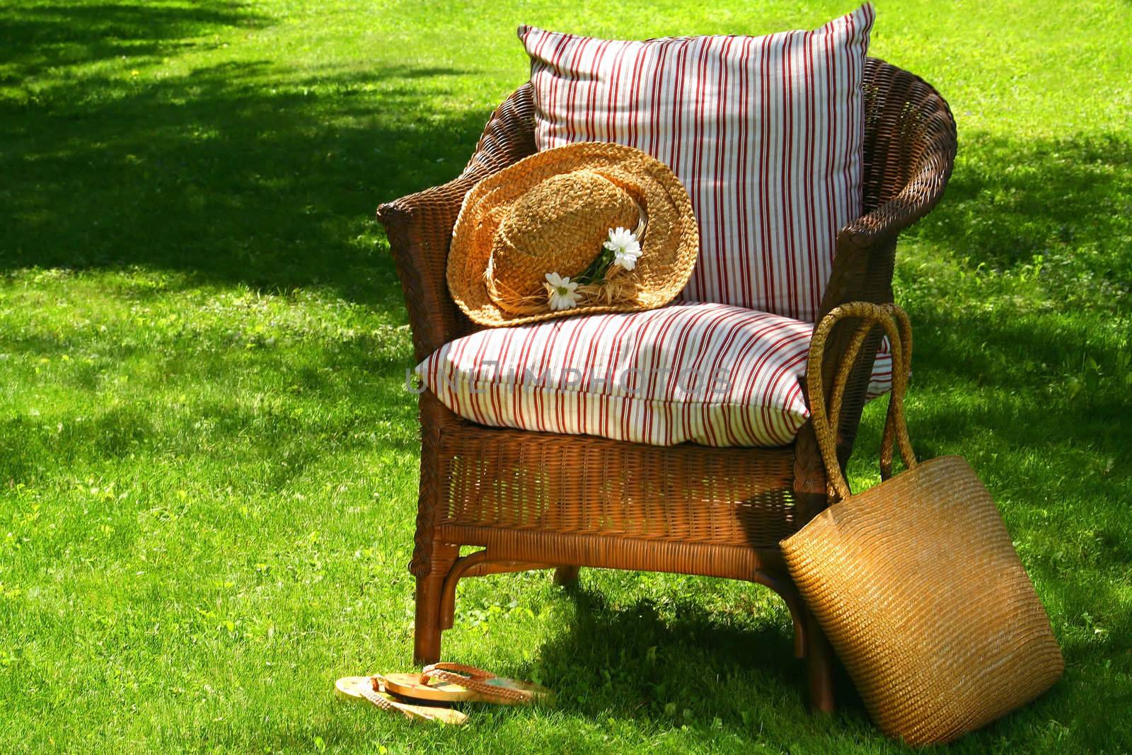 Straw hat, old wicker chair waiting for someone to relax on a hot summer's day
