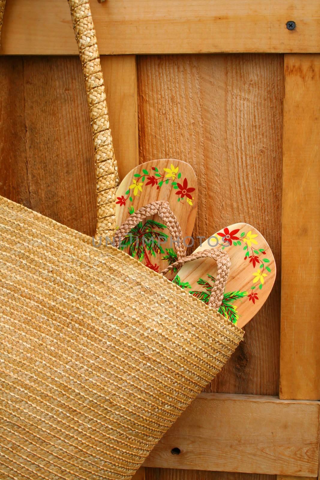Pair of sandals hanging out of wicker purse by Sandralise