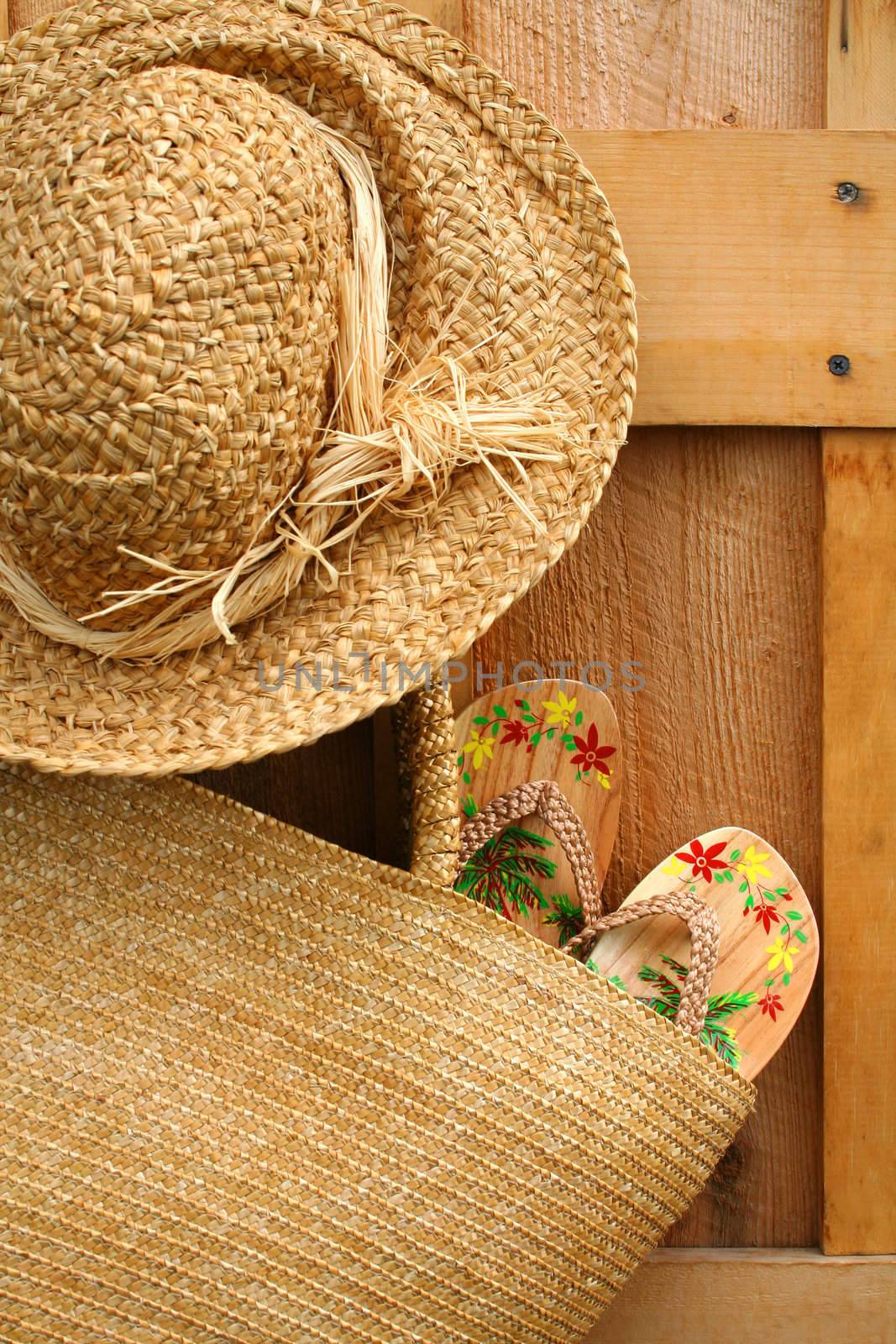 Pair of sandals hanging out of wicker purse with sun hat