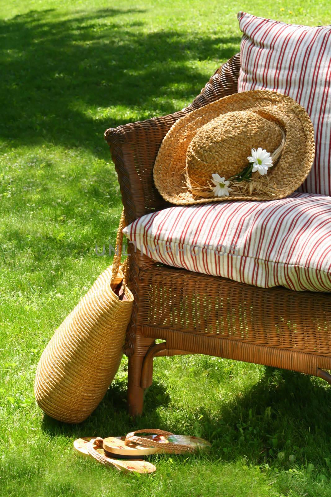 Grass lawn with a wicker chair waiting for someone to relax on a hot summer's day