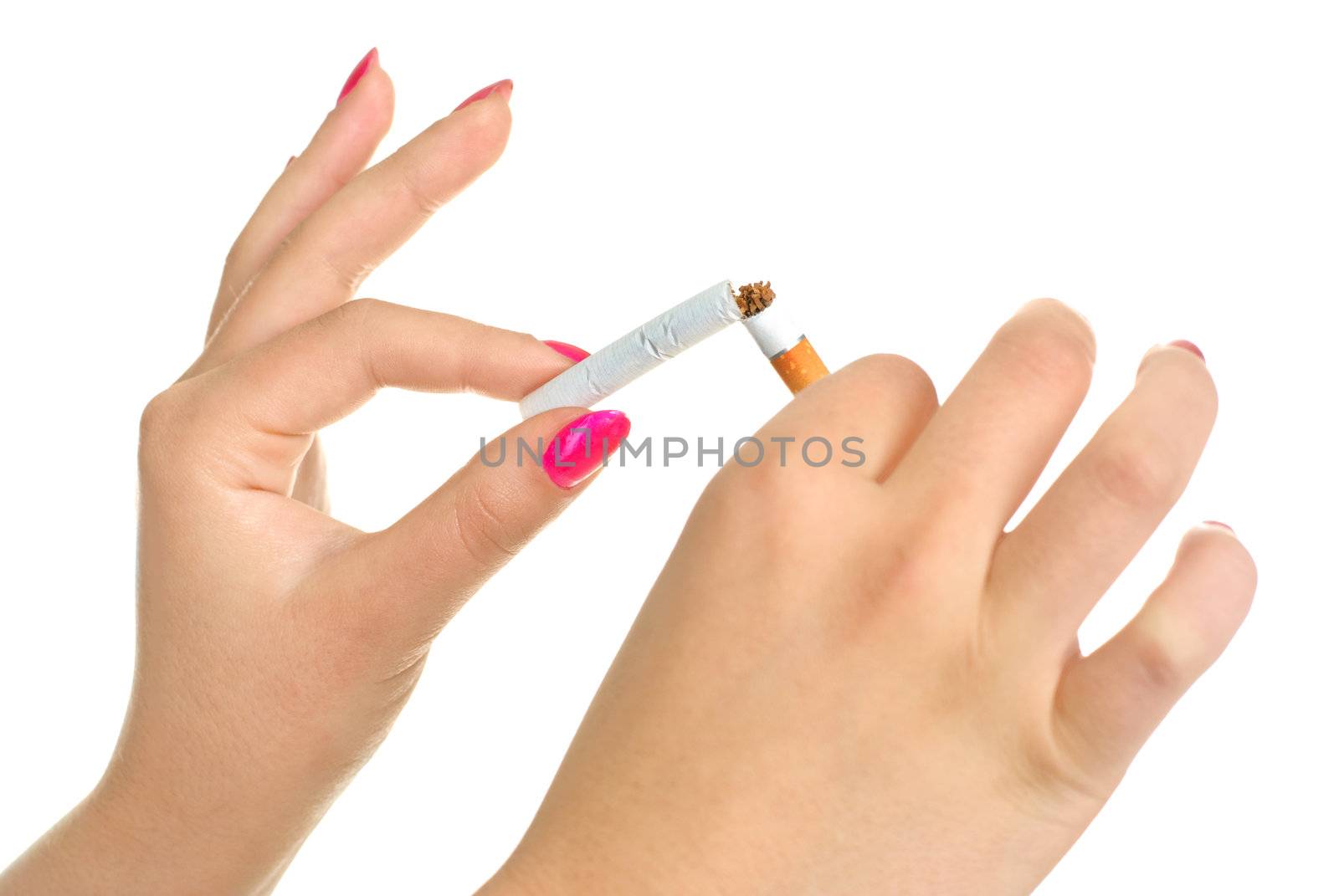 closeup of the hands of a young woman breaking a cigarette 
