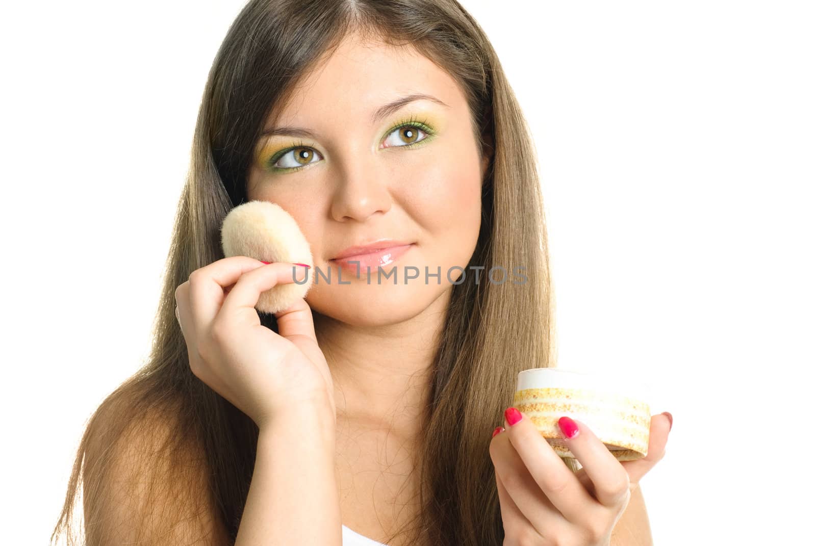 beautiful young woman applying powder with a sponge