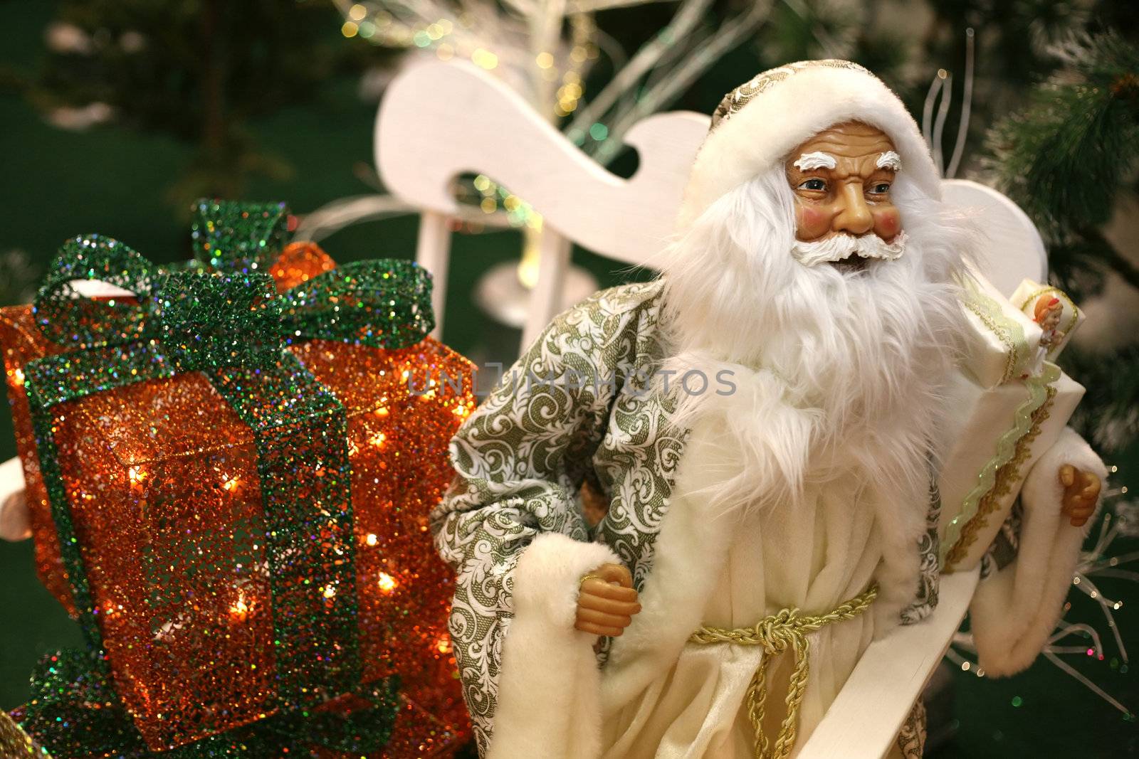 Toy Santa Claus with gifts on white sledge