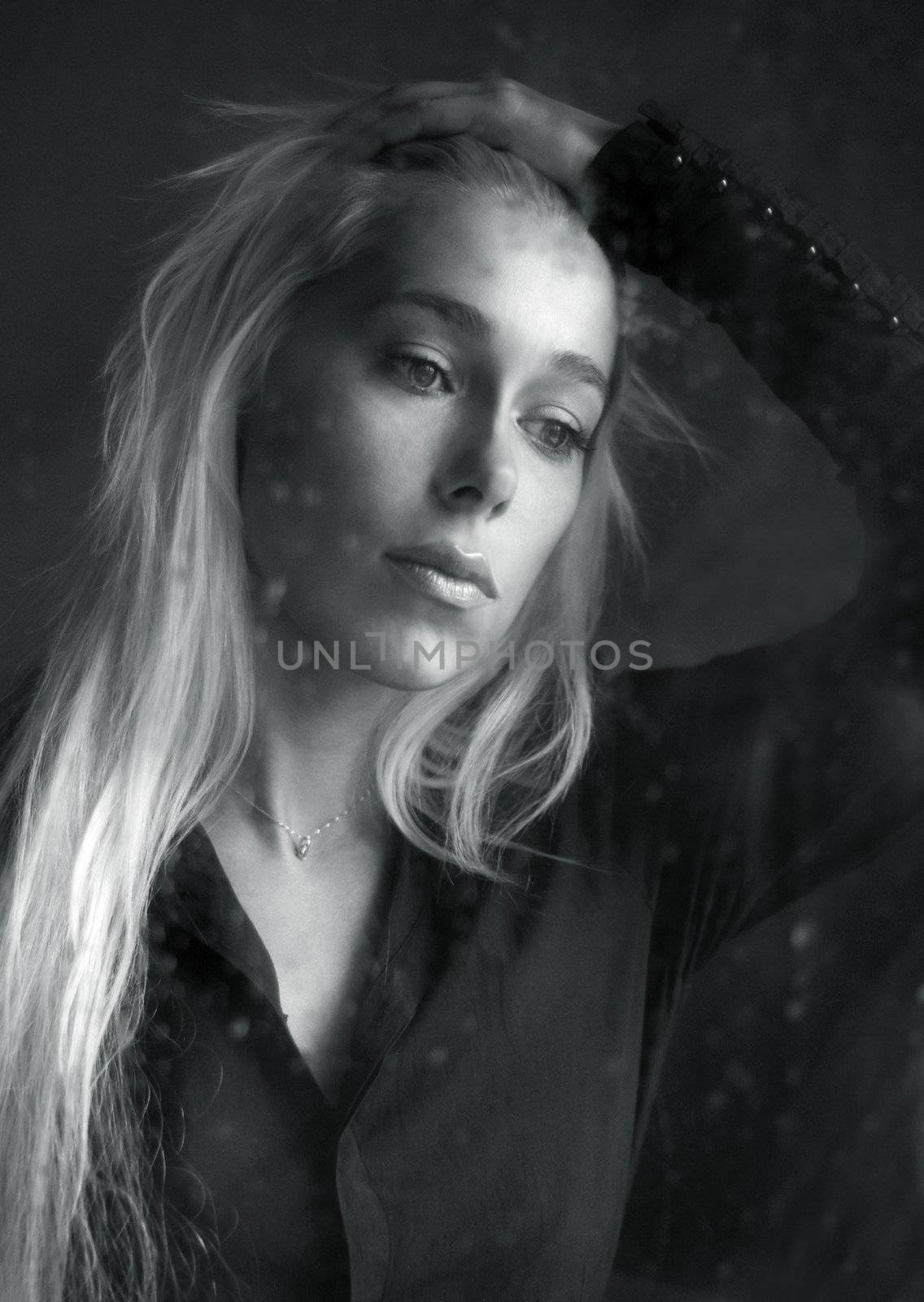 Woman with sad smile behind a wet window. b/w