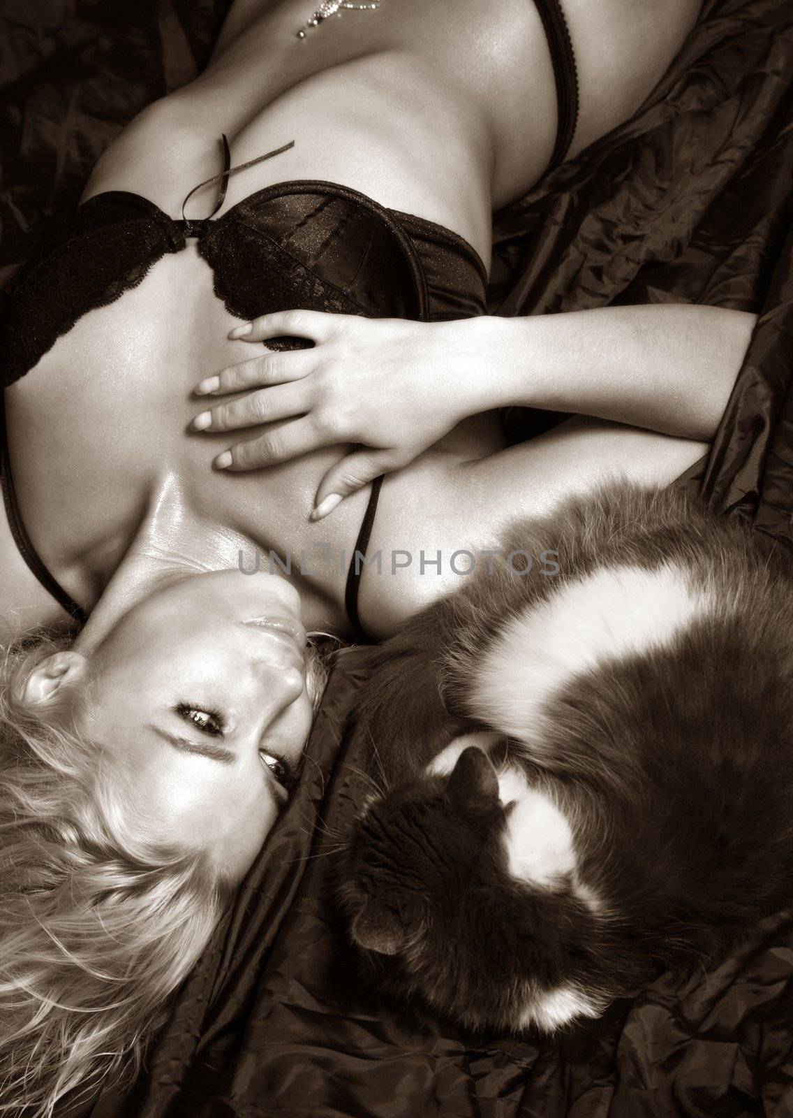 The wet girl and cat lays on a silk fabric. b/w+sepia