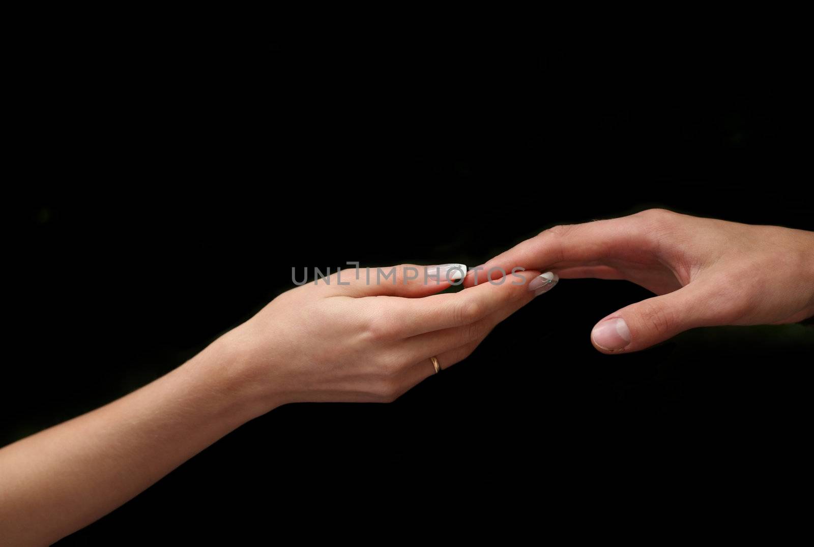 Man's and female hand on a black background