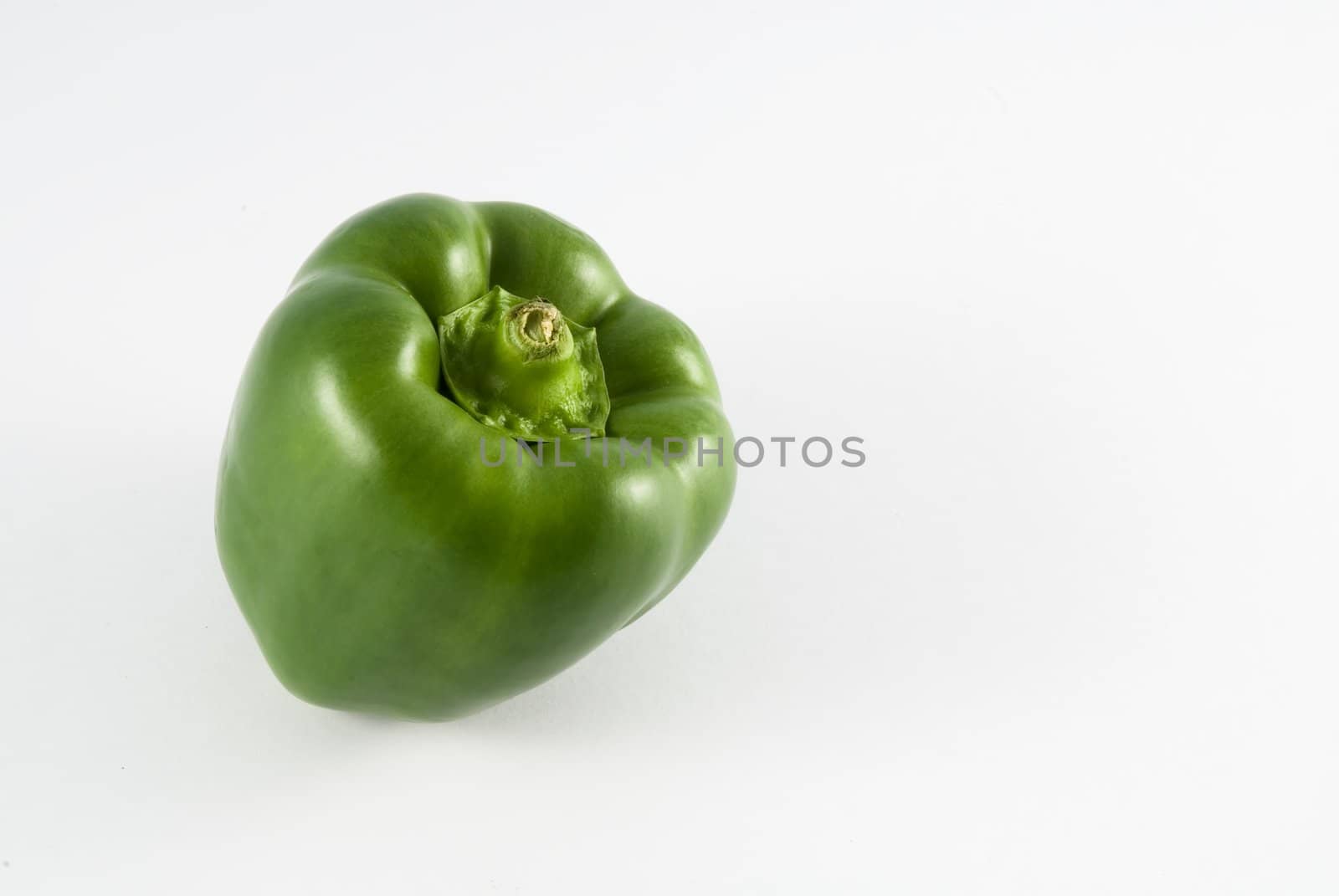 Single green pepper against white background