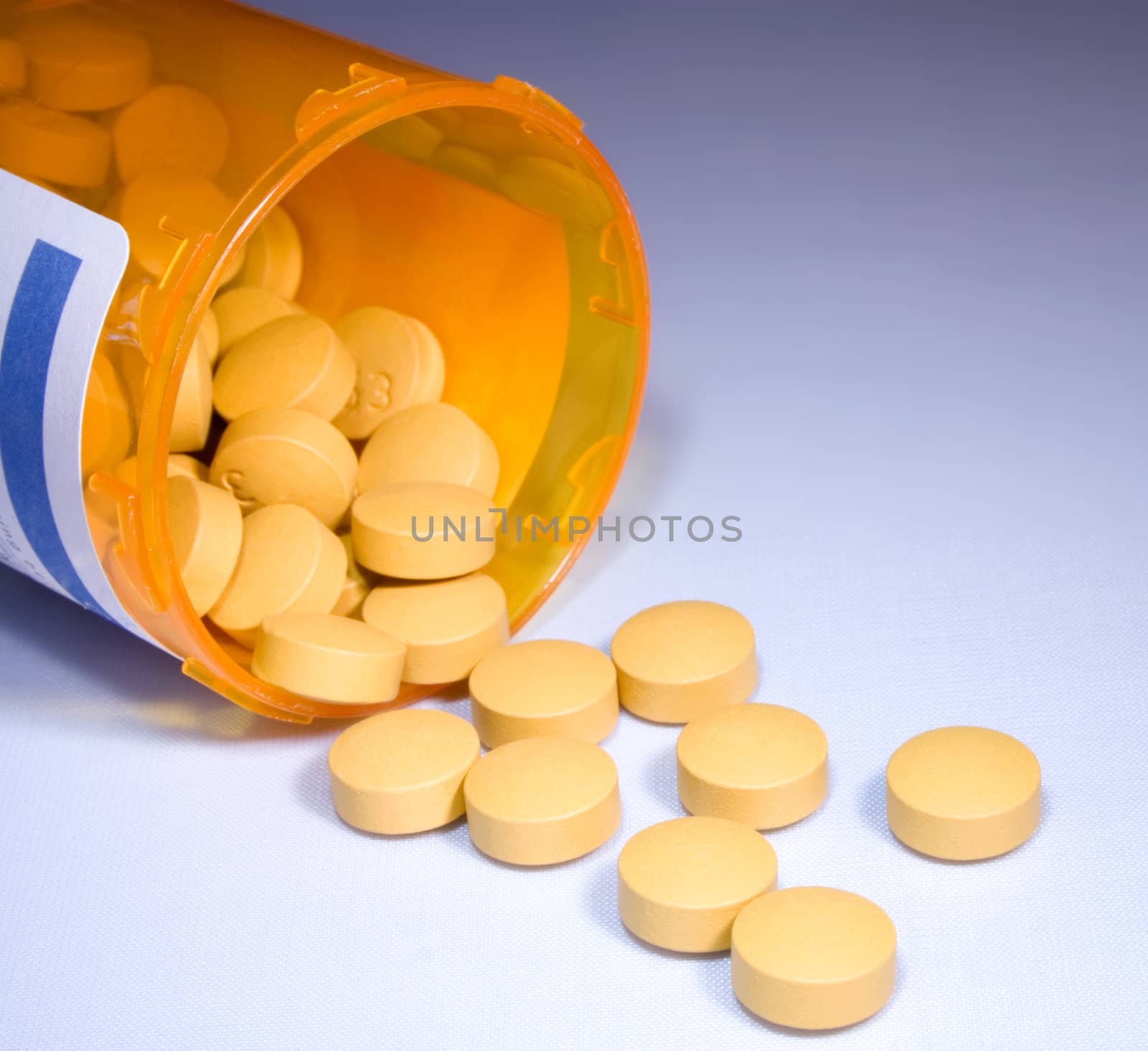 Pills with prescrption bottle on surface