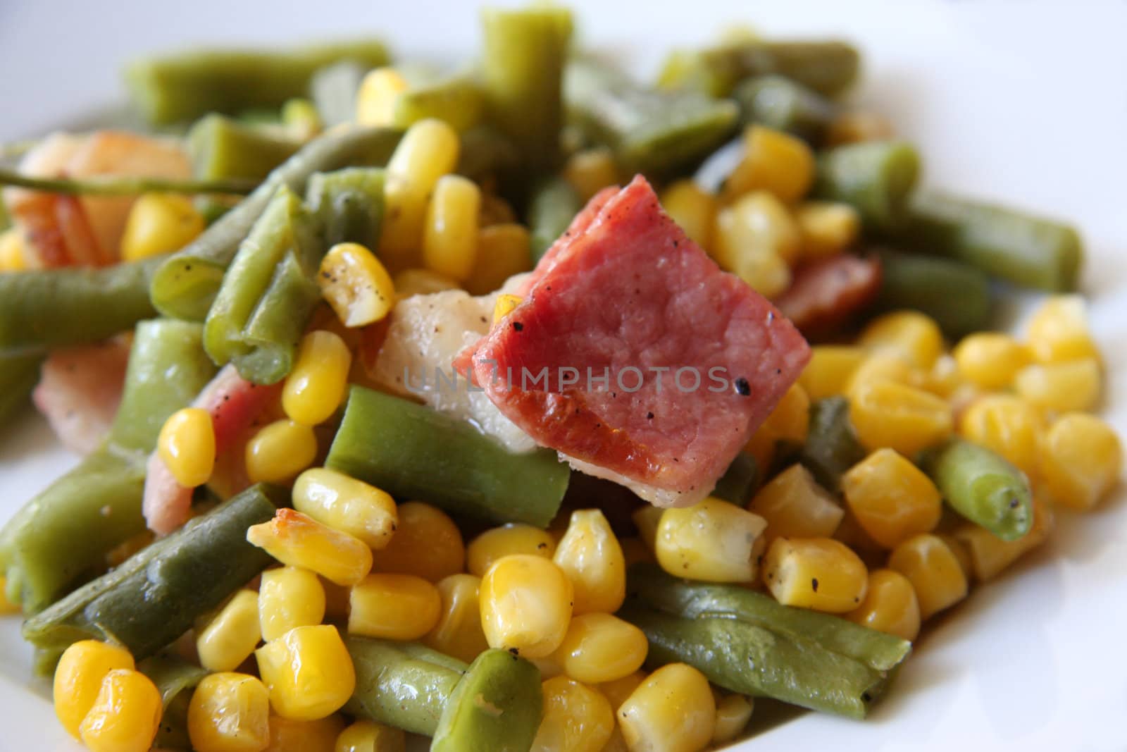 Salad with corn, broccoli and bacon on isolated white